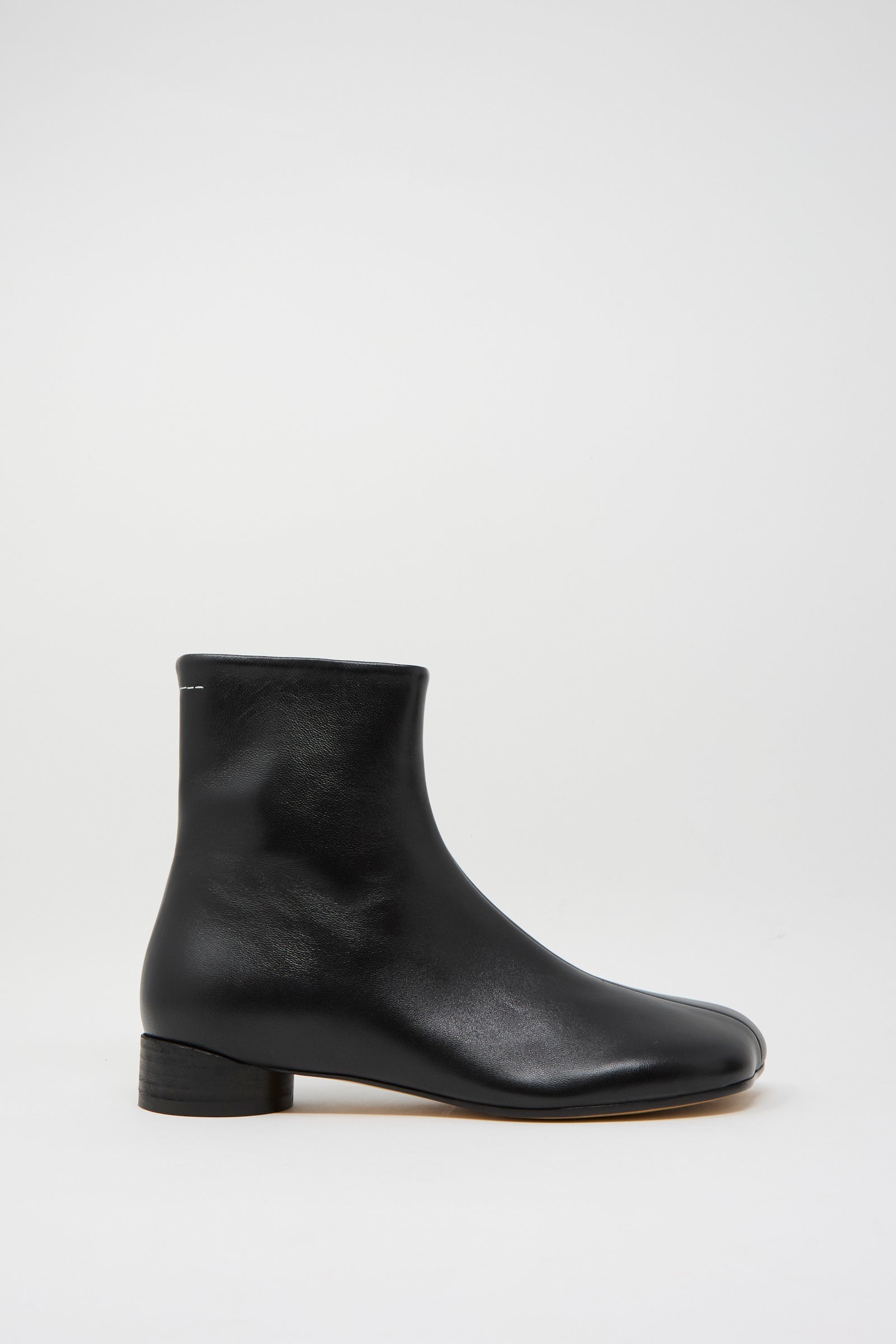 The Ankle Boot in Black by MM6, made from talian calfskin leather, sits elegantly against a plain white background.