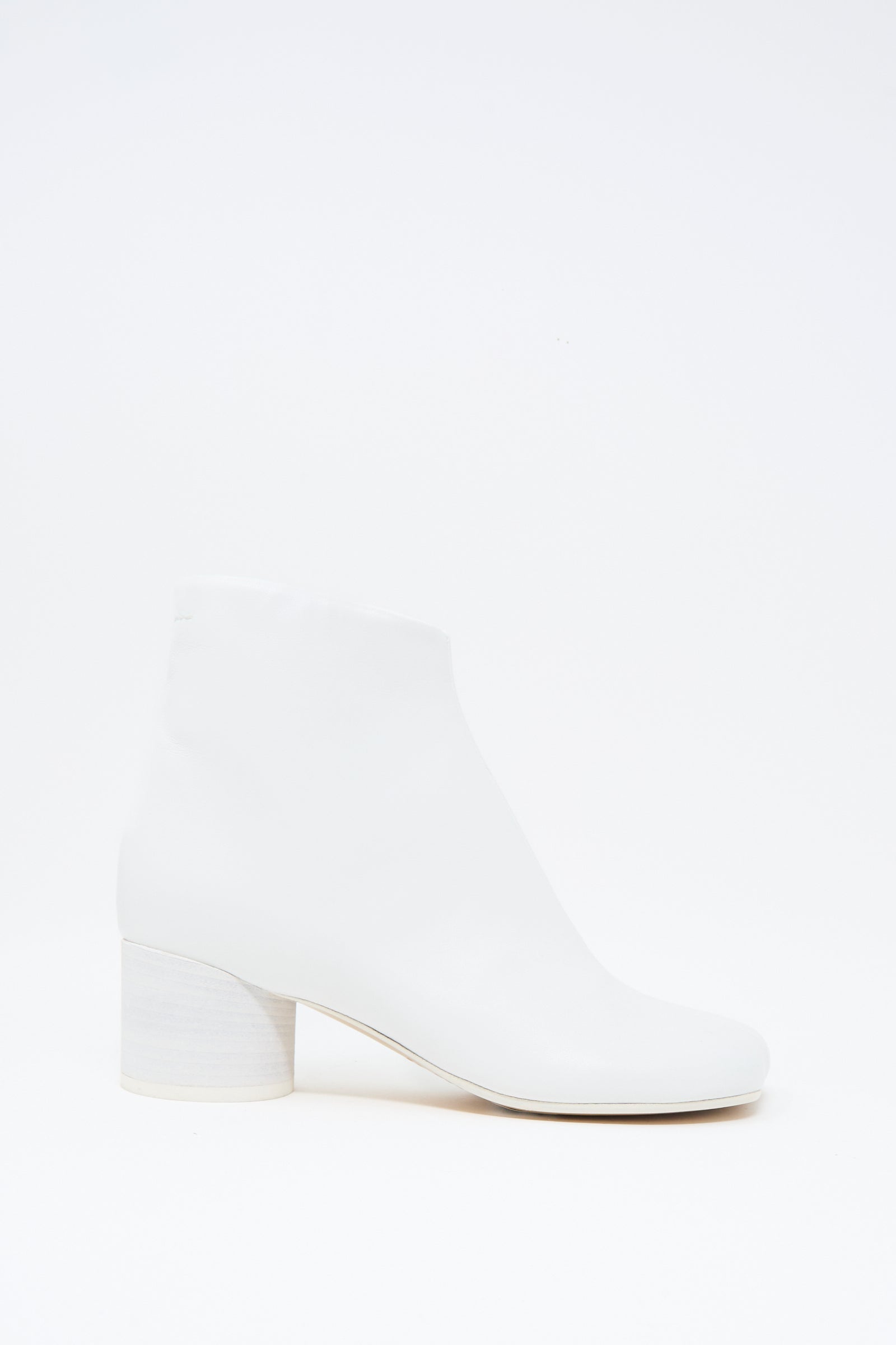 The MM6 Ankle Boot in White features buffed calfskin leather, a rounded toe, and a low chunky heel, shown against a plain white background.