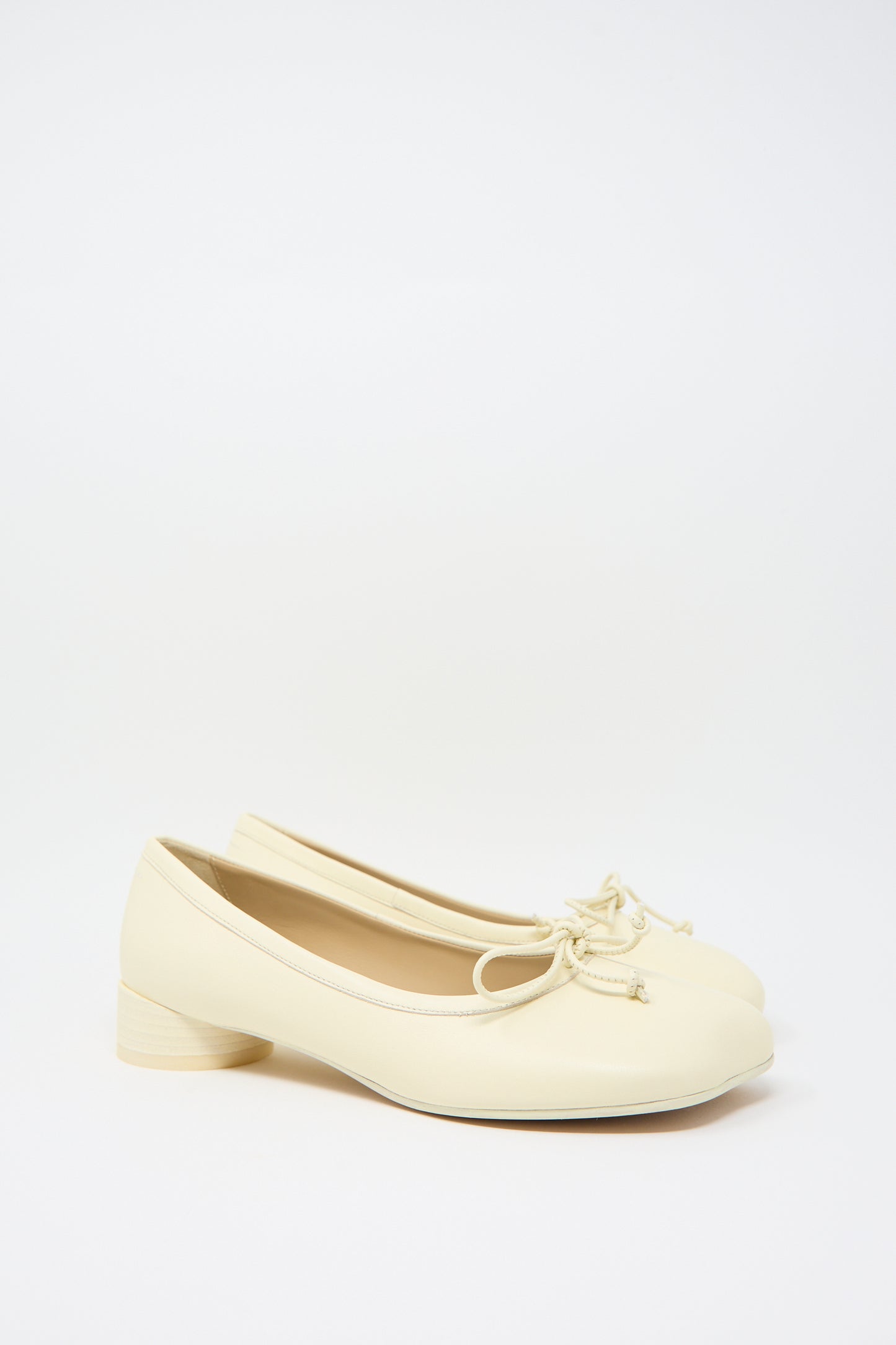 A pair of MM6 Ballet Shoe in Cream leather with front bow detailing on the toes and low cylindrical heels, placed side by side against a plain white background.