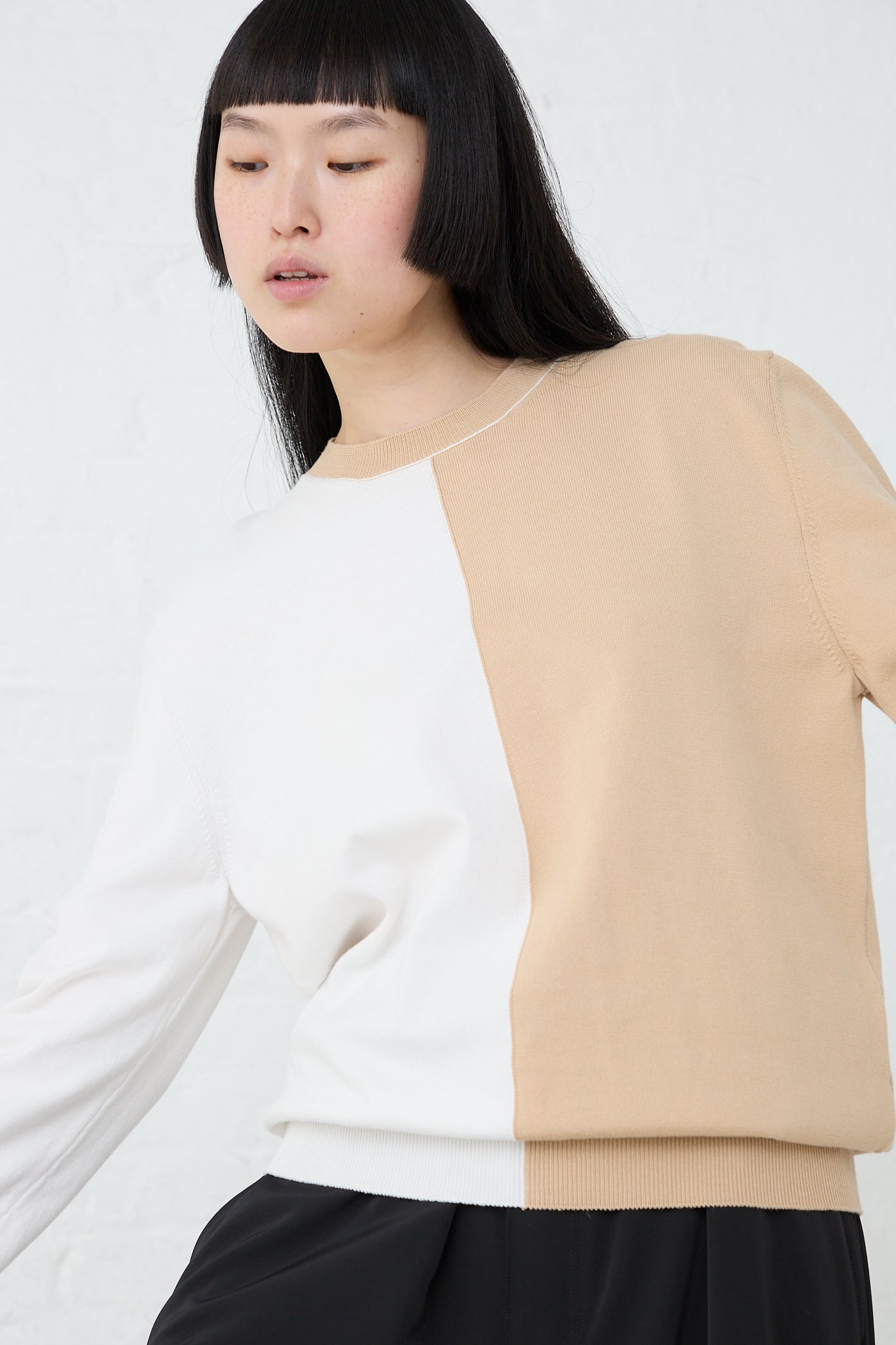 The model is wearing a relaxed fit bi-color MM6 crewneck in Beige Off White.