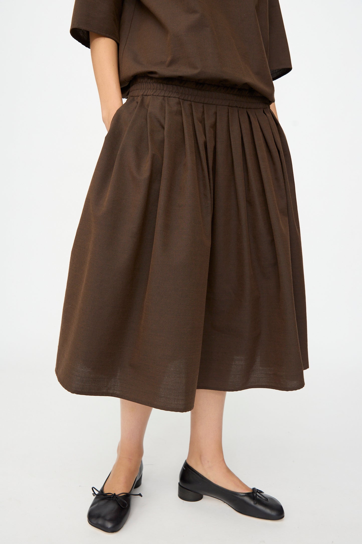A person wearing the MM6 Maxi Dress in Brown and black low-heeled shoes, standing against a plain light background.