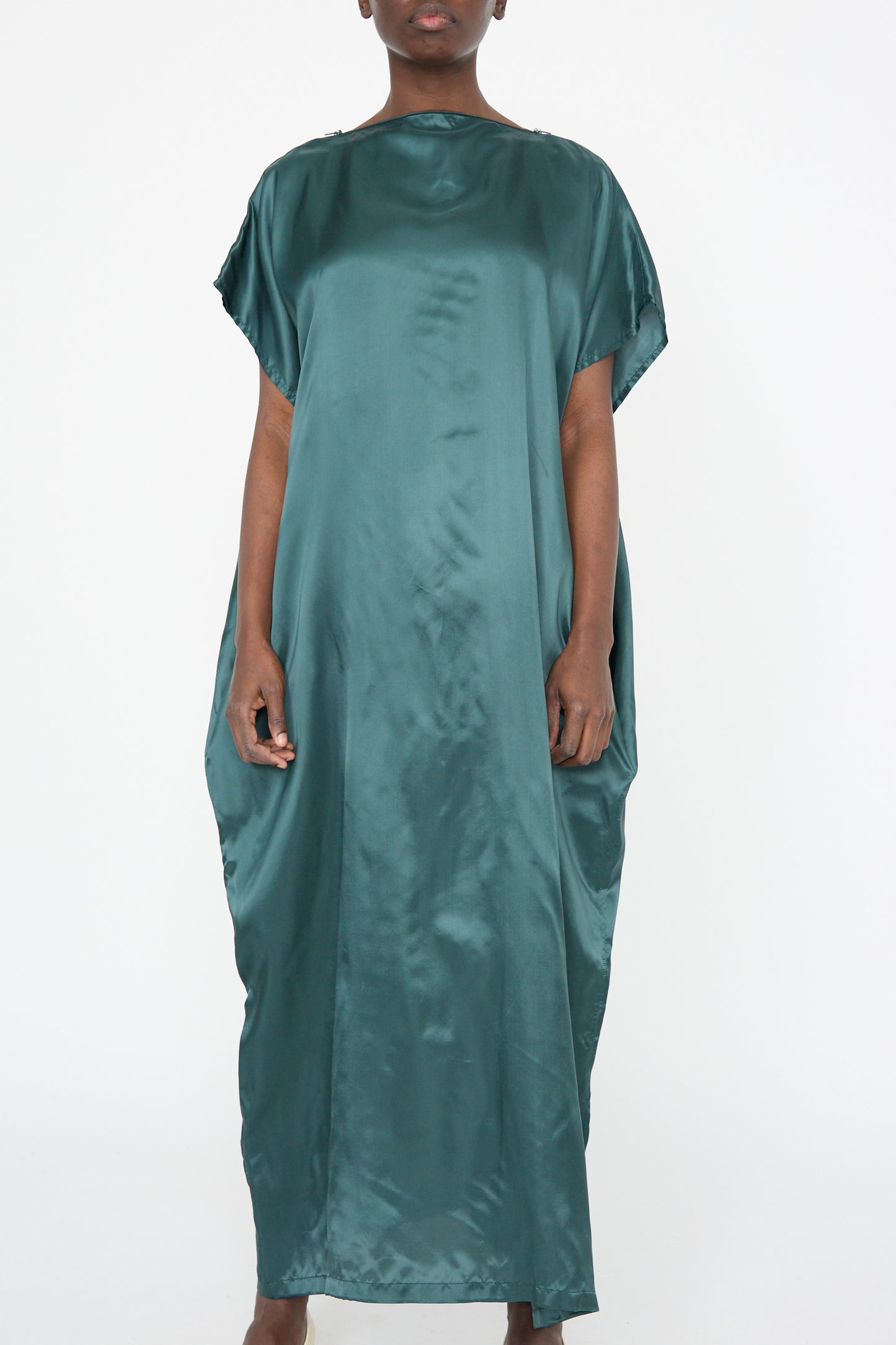 An elegant person wearing the MM6 Maxi Dress in Green stands against a plain white background.