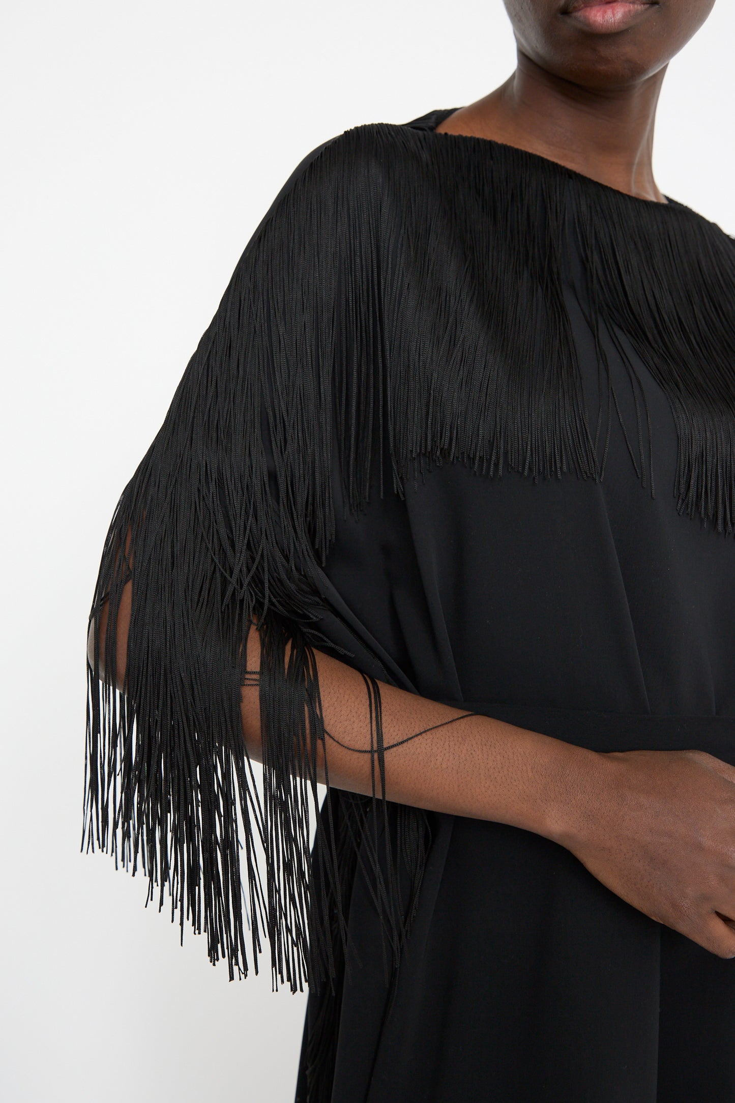 Wearing the MM6 Midi Dress in Black with long fringe sleeve details exudes a stylish vibe. Its relaxed fit enhances comfort, making it perfect for any occasion.