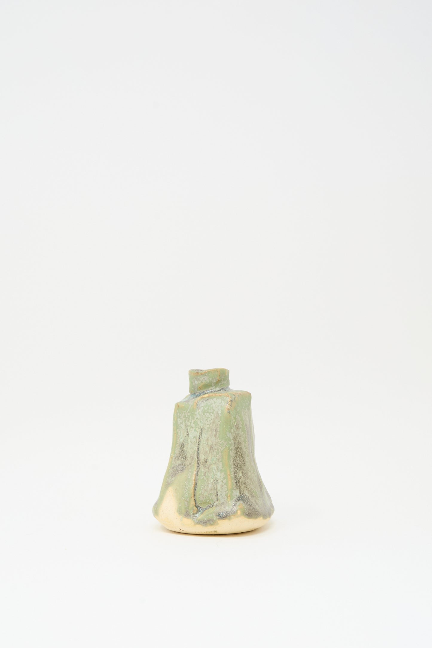 The MONDAYS Carved Bud Vase in Lichen Green is a handmade ceramic piece with a tree stump design and green-beige glaze, shown on a plain white background.