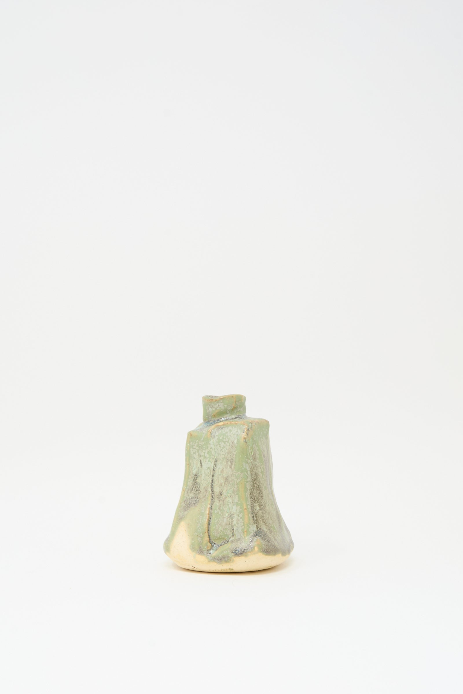 The MONDAYS Carved Bud Vase in Lichen Green is a handmade ceramic piece with a tree stump design and green-beige glaze, shown on a plain white background.