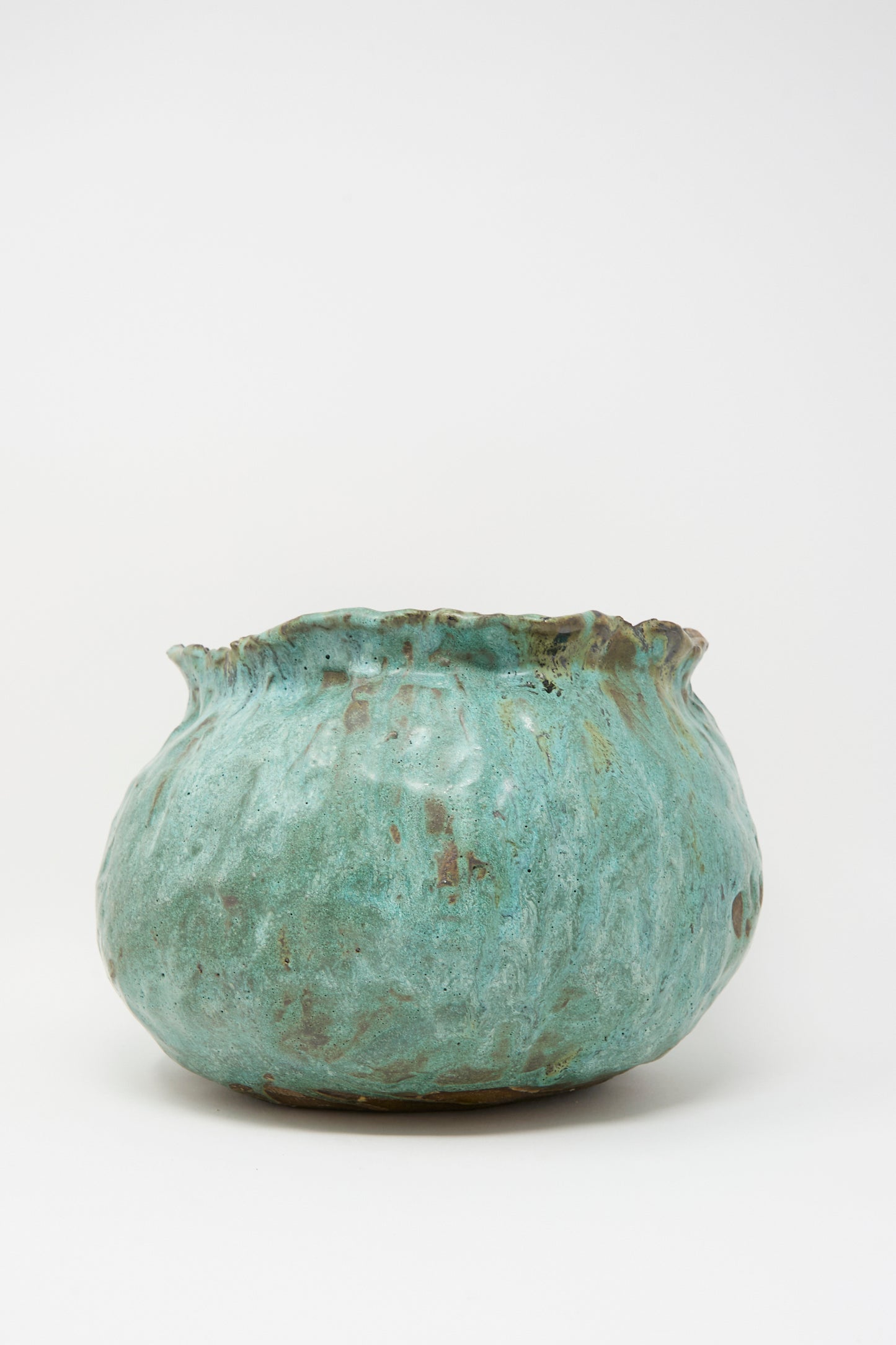 The MONDAYS Coiled Urn in Green features a round, textured hand-coiled shape with a wide, uneven rim and mottled turquoise-green glaze, displayed on a plain white background.