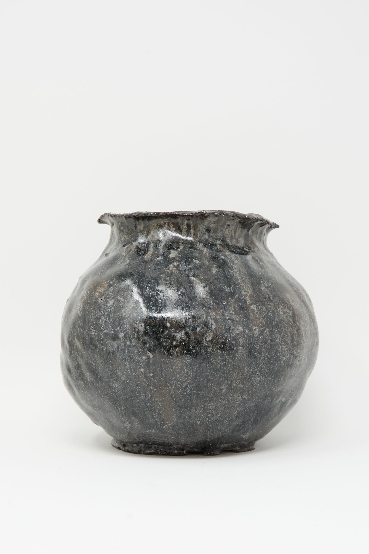 The MONDAYS Coiled Vase in Black features a round, hand-coiled design with a slightly flared, uneven rim and a textured, glossy dark gray finish, displayed against a plain white background.