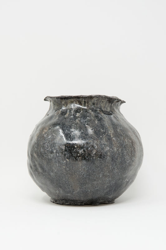 The MONDAYS Coiled Vase in Black features a round, hand-coiled design with a slightly flared, uneven rim and a textured, glossy dark gray finish, displayed against a plain white background.