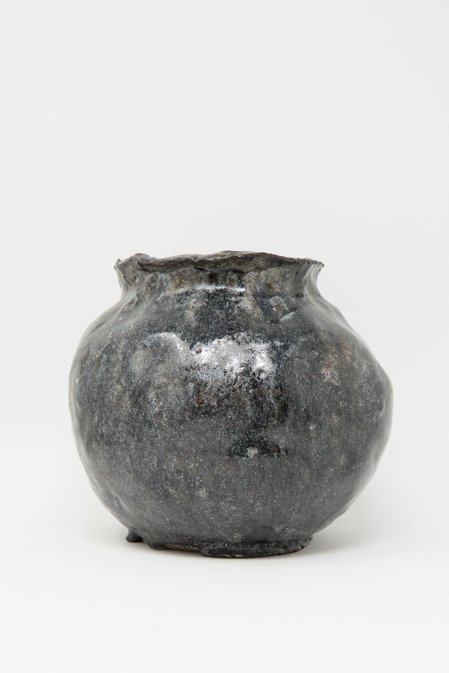 The MONDAYS Coiled Vase in Black is a round, hand-coiled vase with a wide body, narrow opening, and uneven rim, displayed against a plain white background.