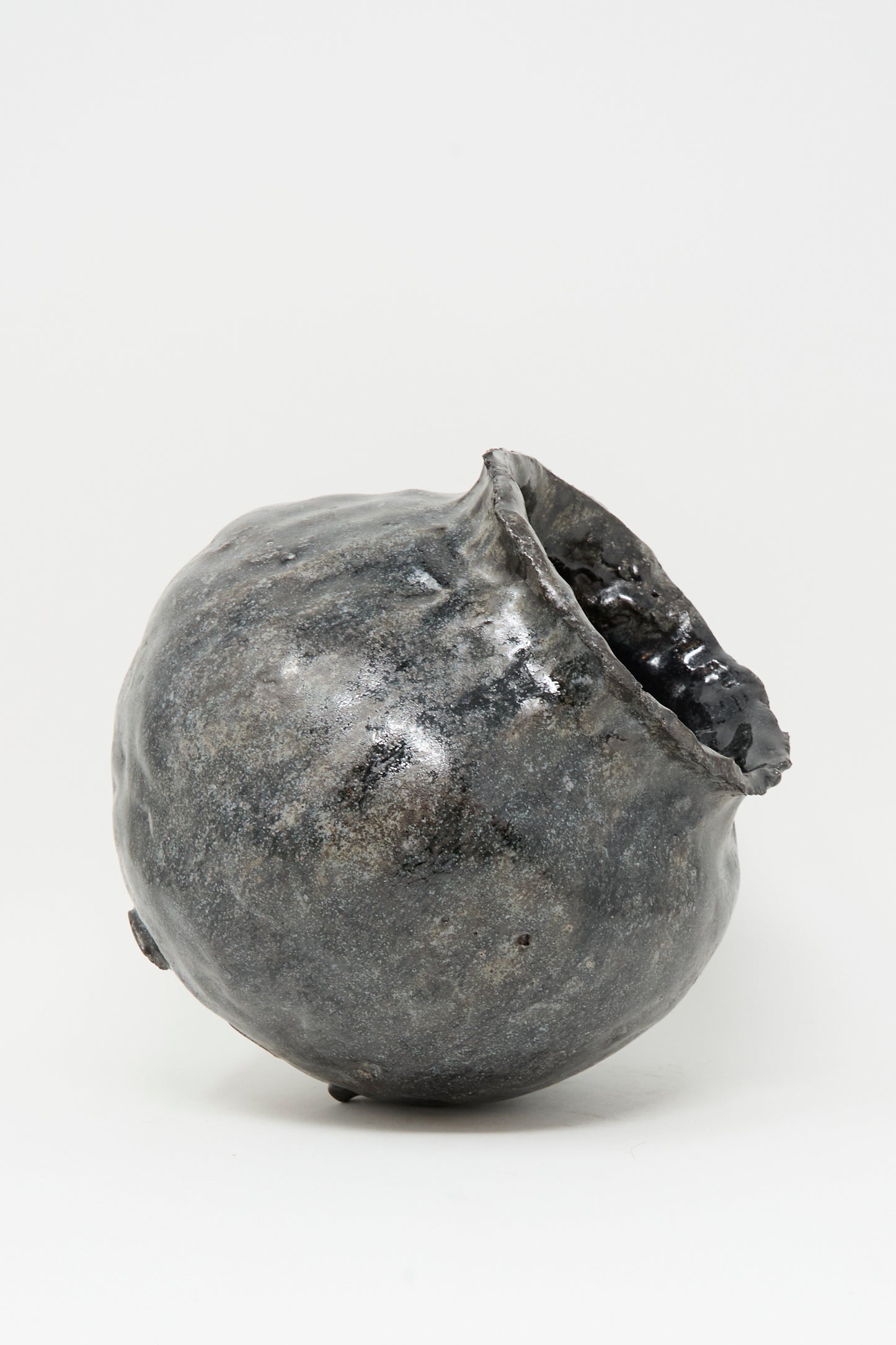 The MONDAYS Coiled Vase in Black is a round, hand-coiled vase with an uneven shape, rough metallic dark gray finish, and wide opening, crafted in Brooklyn and shown on a plain white background.