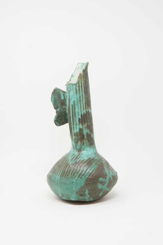 The MONDAYS Corrugated Pitcher in Green II features a textured ceramic surface, uneven base, and jagged top reminiscent of Brooklyn pottery, displayed against a plain white background.