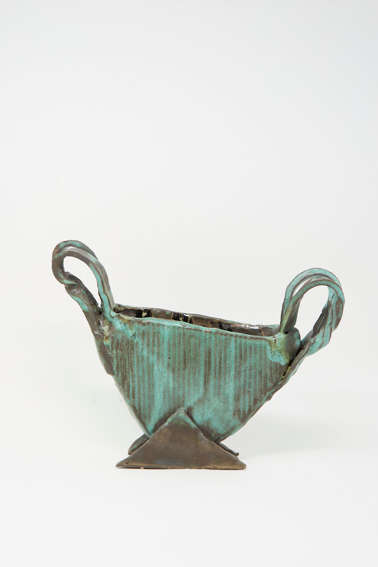 The MONDAYS Corrugated Vessel with Handles in Green is a small, handmade geometric piece from Upstate NY featuring two twisted handles and a triangular base, displayed against a plain white background.