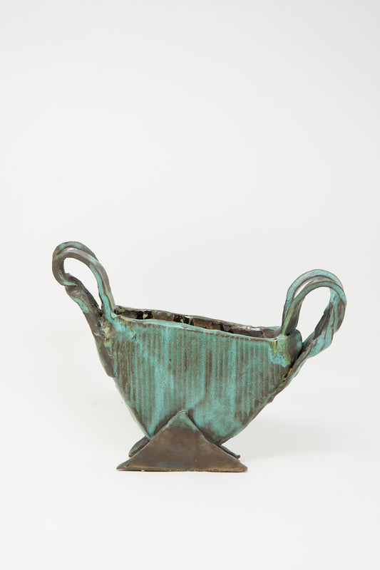 The MONDAYS Corrugated Vessel with Handles in Green is a small, handmade geometric piece from Upstate NY featuring two twisted handles and a triangular base, displayed against a plain white background.