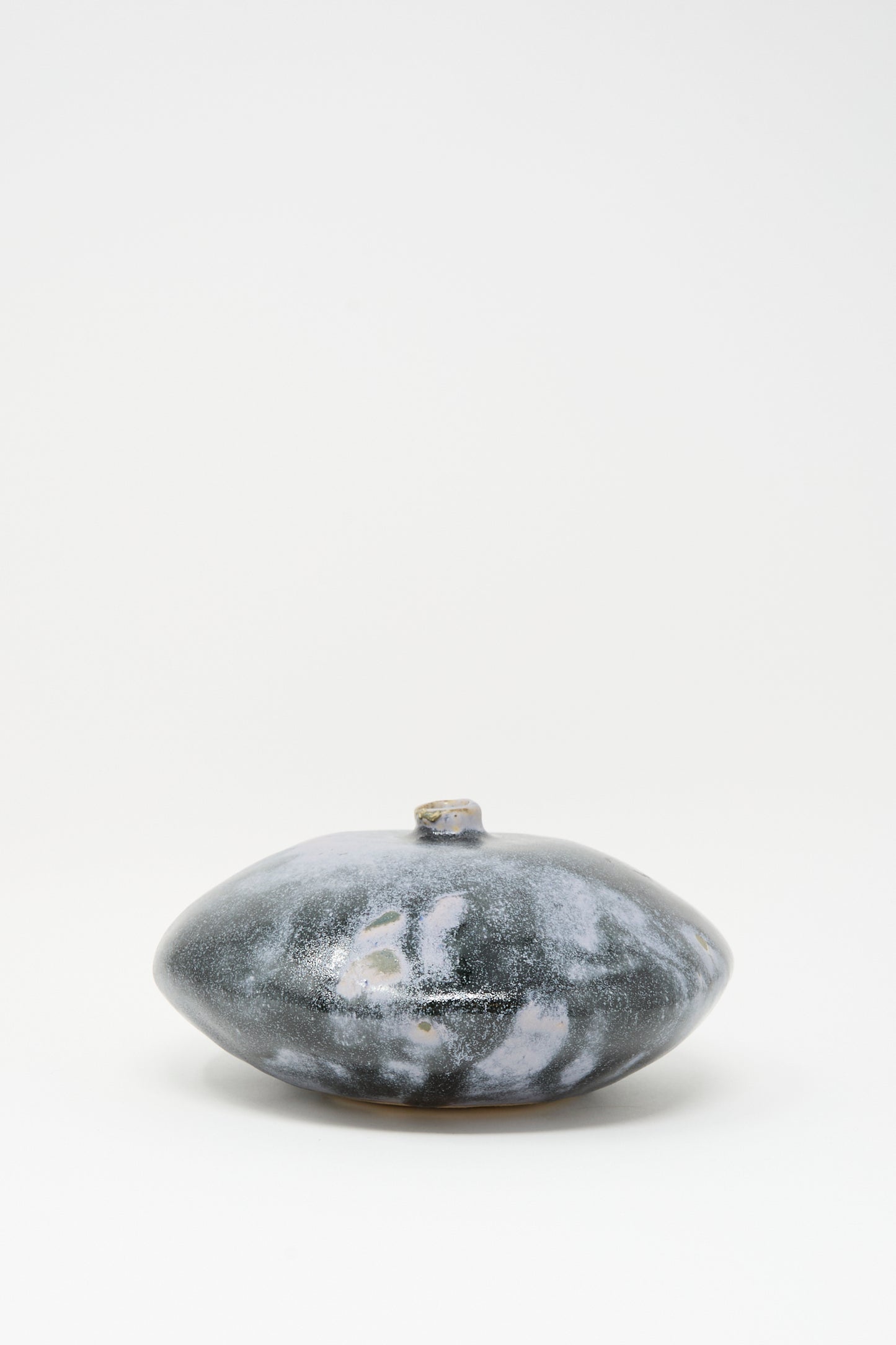 The Doyle Vase in Storm by MONDAYS is a rounded, flat handmade vase with a marbled gray and white glaze and a small narrow opening, shown against a plain white background.