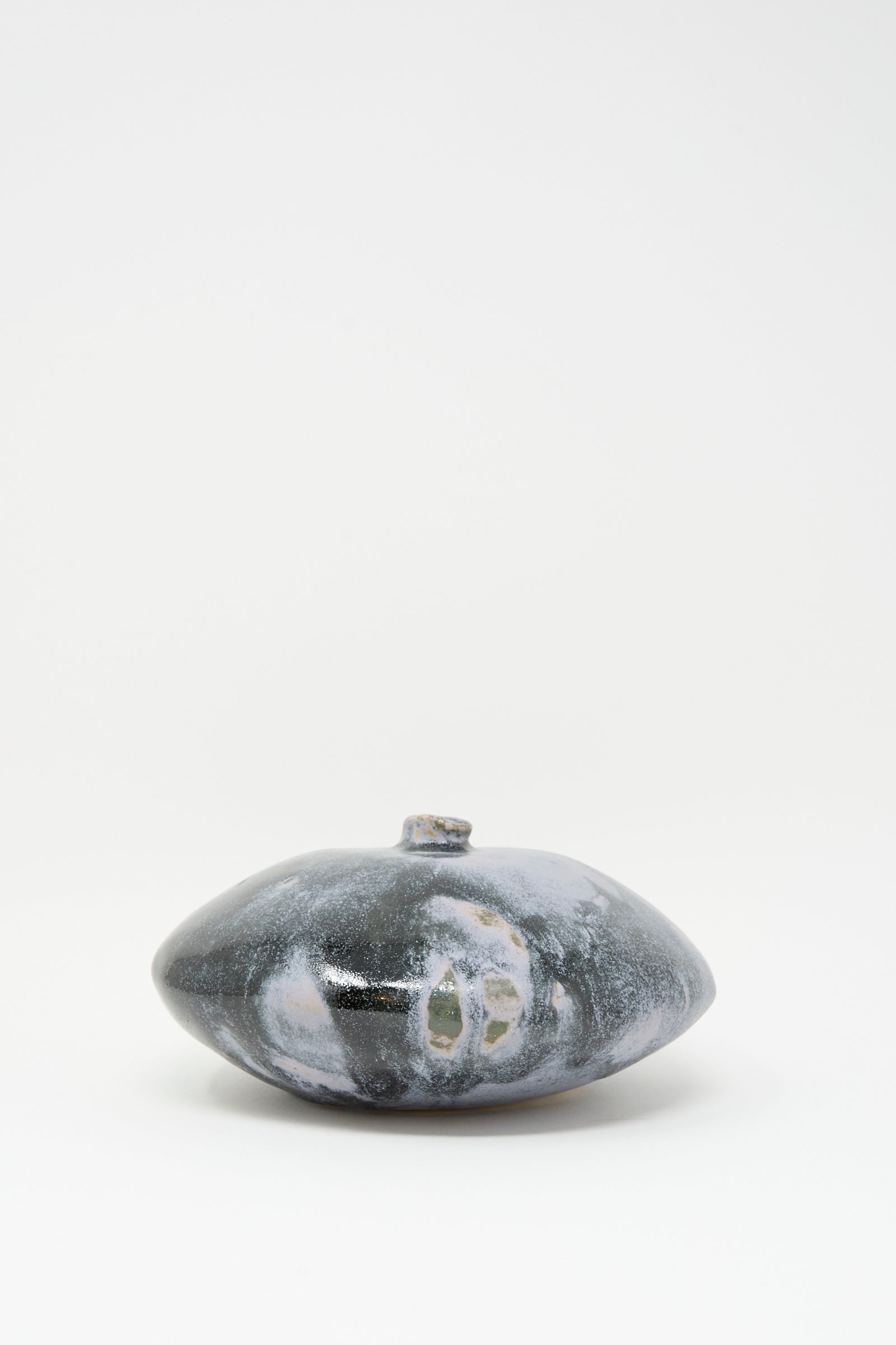 The Doyle Vase in Storm by MONDAYS is a handmade, round, flat dark gray vase with a small neck and white and light gray patterns, shown against a plain white background.