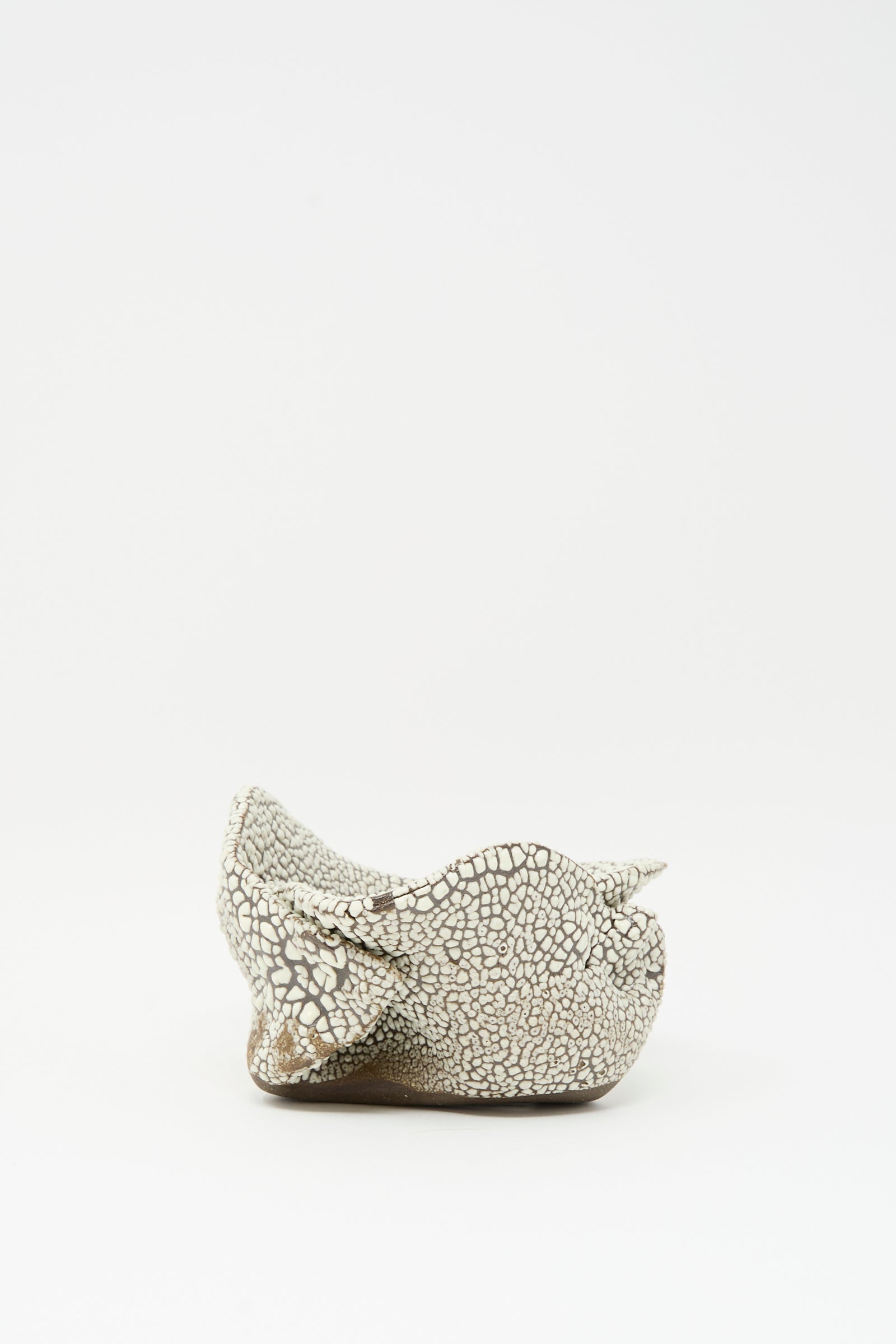 The Folded Bowl in Crawl I by MONDAYS is a small, hand-built bowl from Brooklyn featuring a textured, cracked white glaze and horn-like details, photographed against a plain white background.