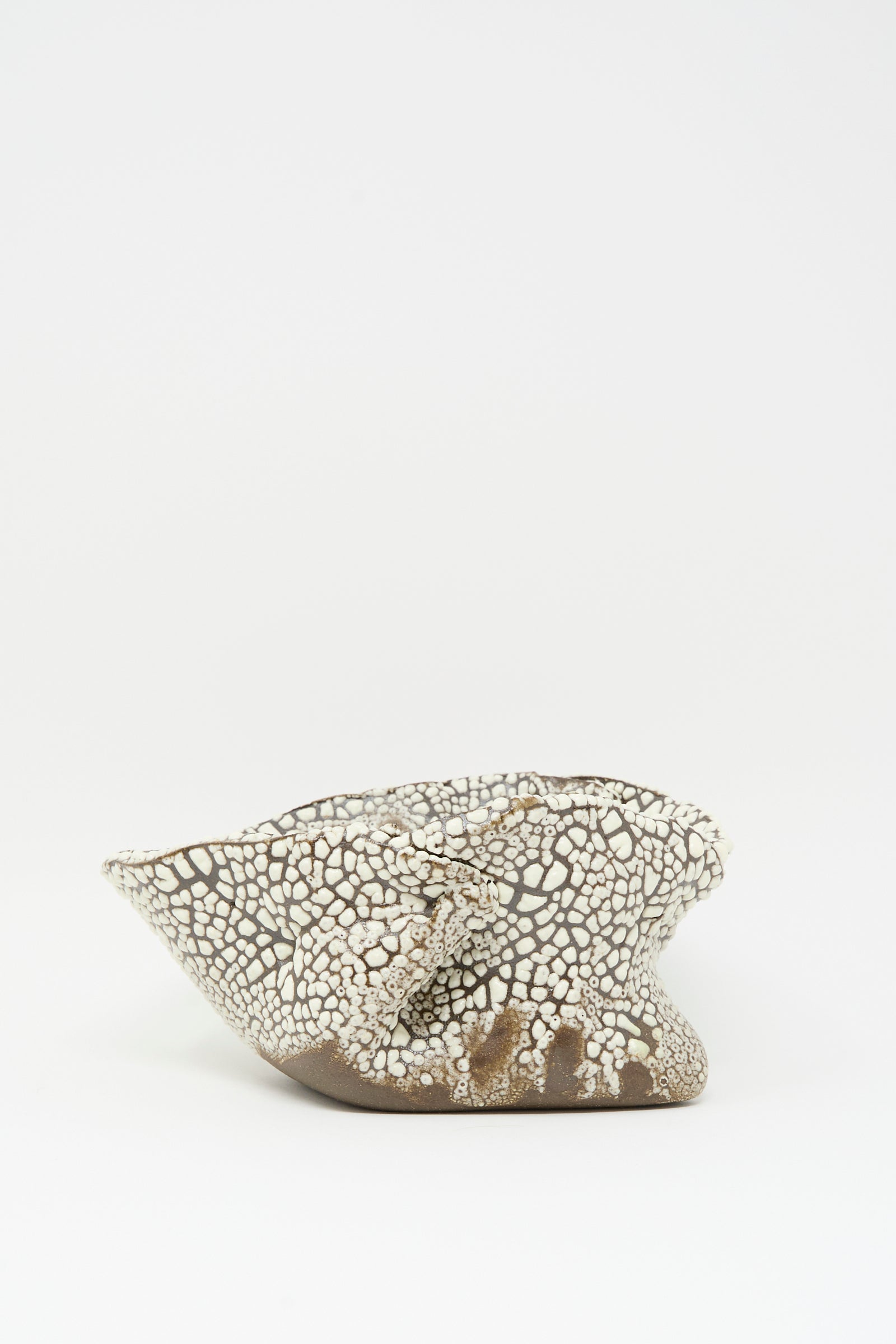 The Folded Bowl in Crawl III by MONDAYS features a hand-built, irregular organic shape and textured crackled white surface with a crawling glaze, displayed against a plain white background.