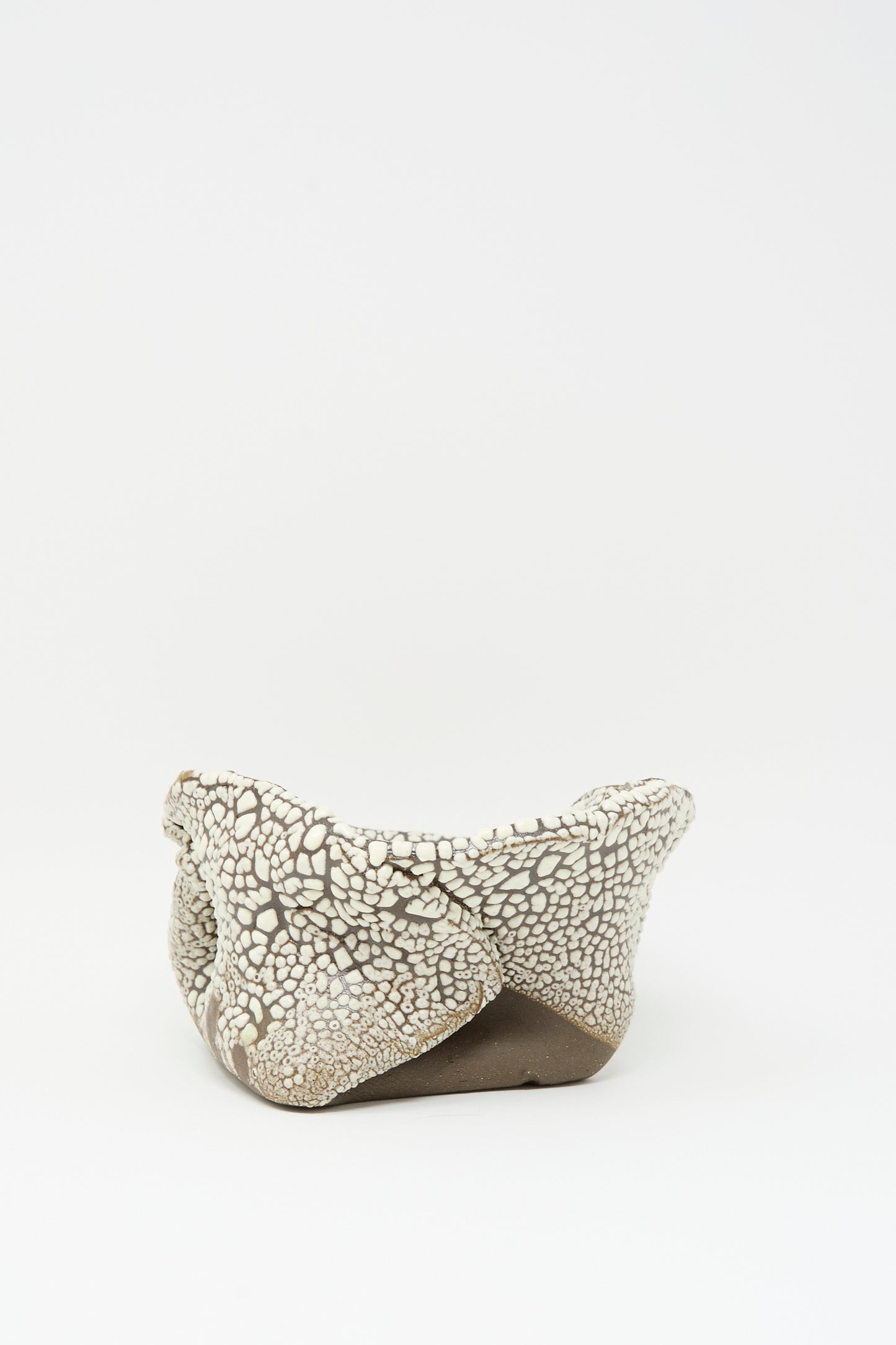 The Folded Bowl in Crawl III by MONDAYS features a hand-built, irregular ceramic form with a unique crawling white glaze, shown on a plain white background.