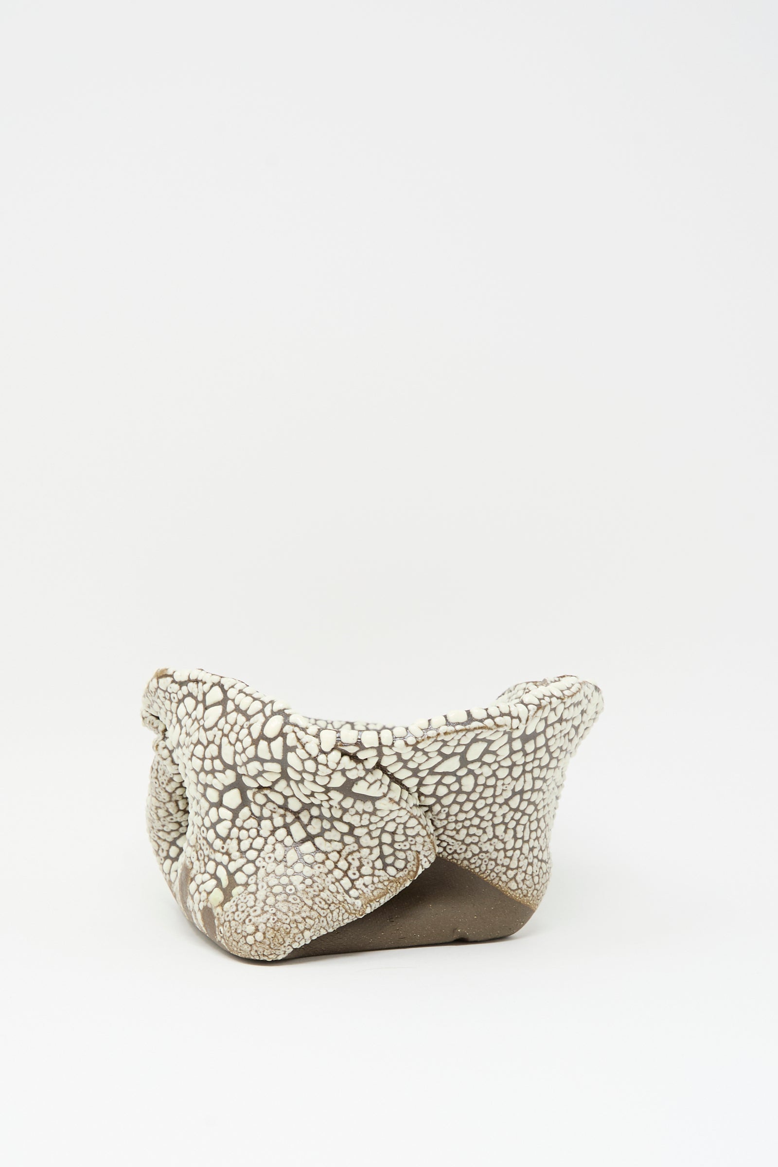The Folded Bowl in Crawl III by MONDAYS features a hand-built, irregular ceramic form with a unique crawling white glaze, shown on a plain white background.