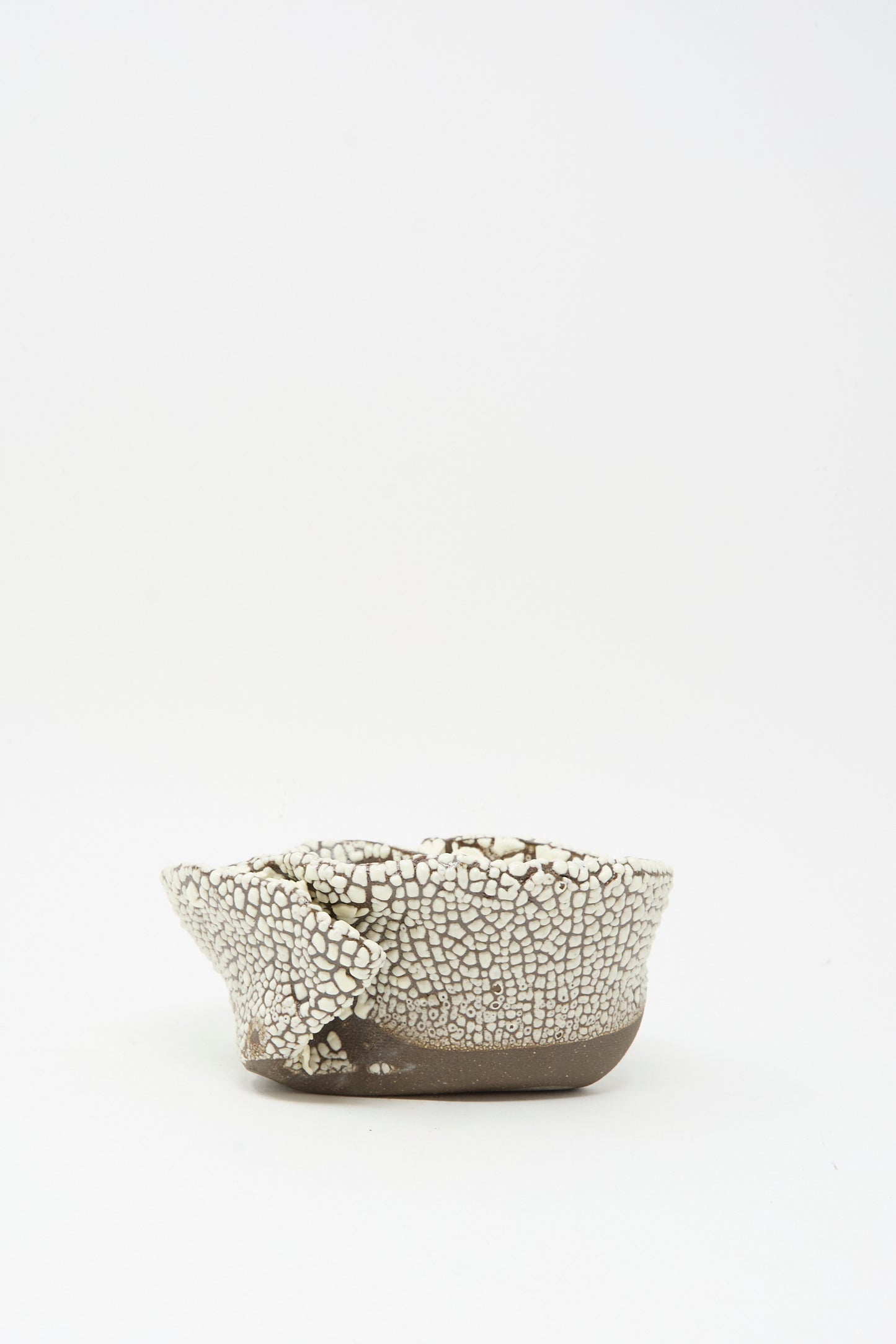 The MONDAYS Folded Wavy Bowl in Crawl II features a small, round hand-built form with a crawling white glaze and uneven rim, showcased against a plain white background—a piece echoing Brooklyn craftsmanship.
