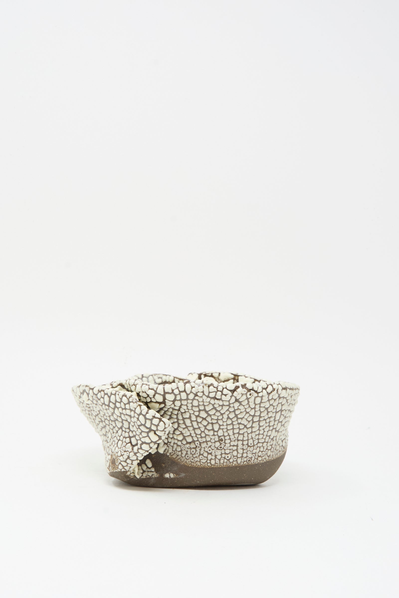 The MONDAYS Folded Wavy Bowl in Crawl II features a small, round hand-built form with a crawling white glaze and uneven rim, showcased against a plain white background—a piece echoing Brooklyn craftsmanship.