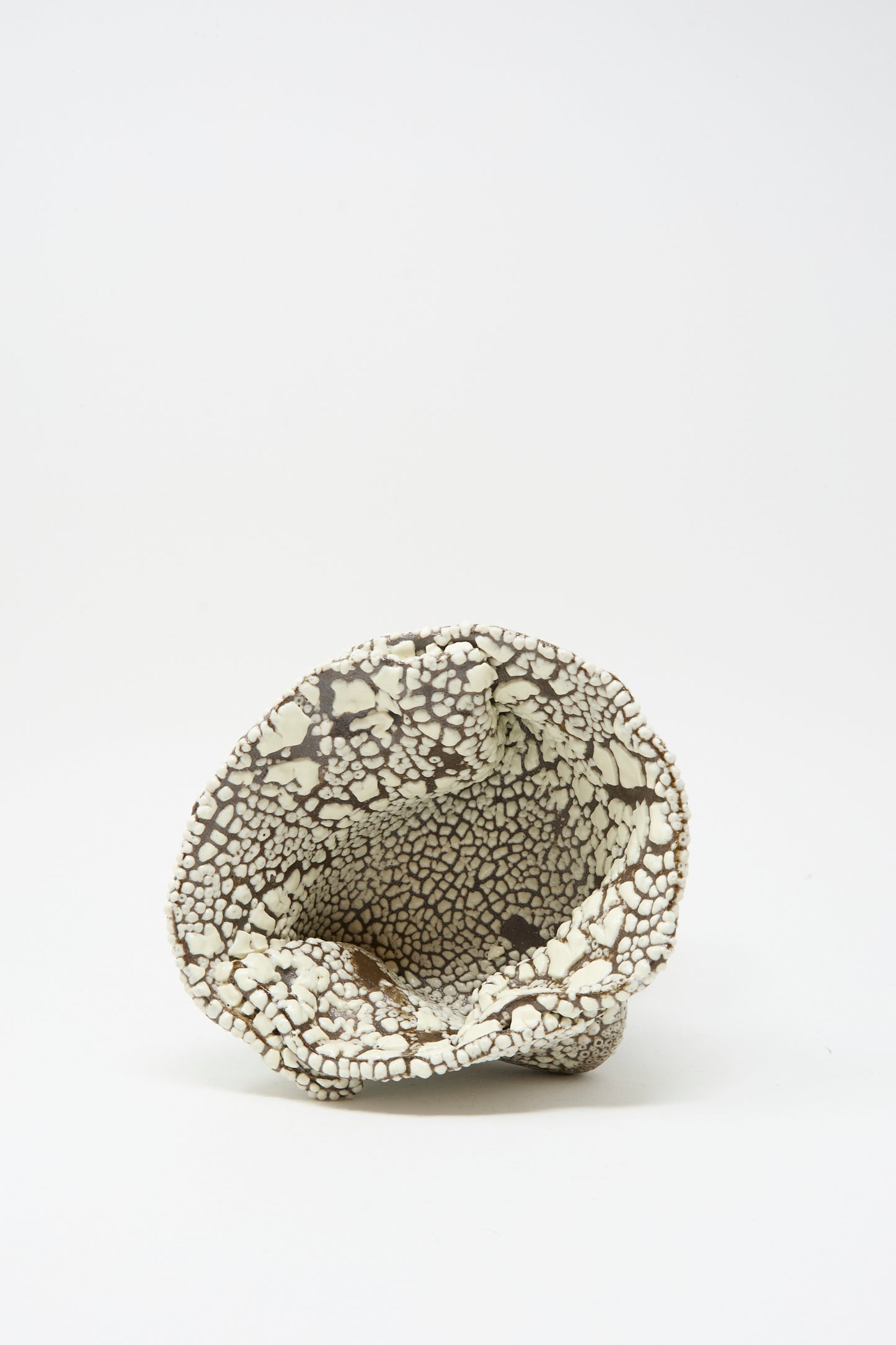 The MONDAYS Folded Wavy Bowl in Crawl II is a small, hand-built bowl with an irregular shape and a cracked black-and-white crawl glaze, photographed on a plain white background.