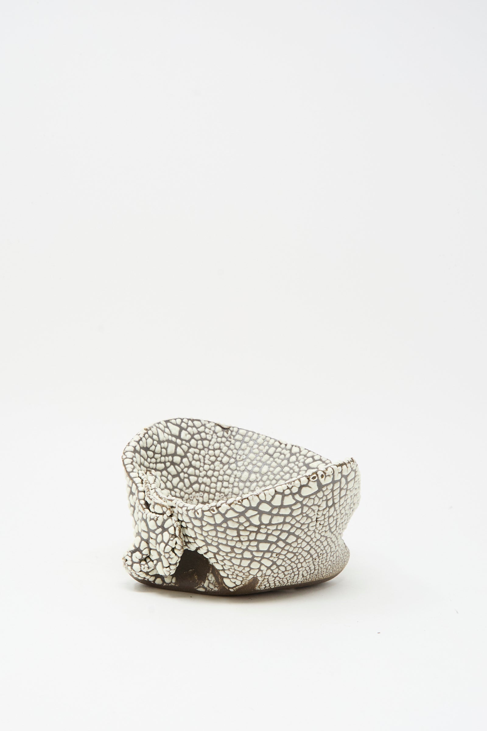 The Folded Wavy Bowl in Crawl III by MONDAYS features a hand-built, white and brown textured surface with hints of white glaze, evoking Brooklyn craftsmanship, and is shown on a plain white background.