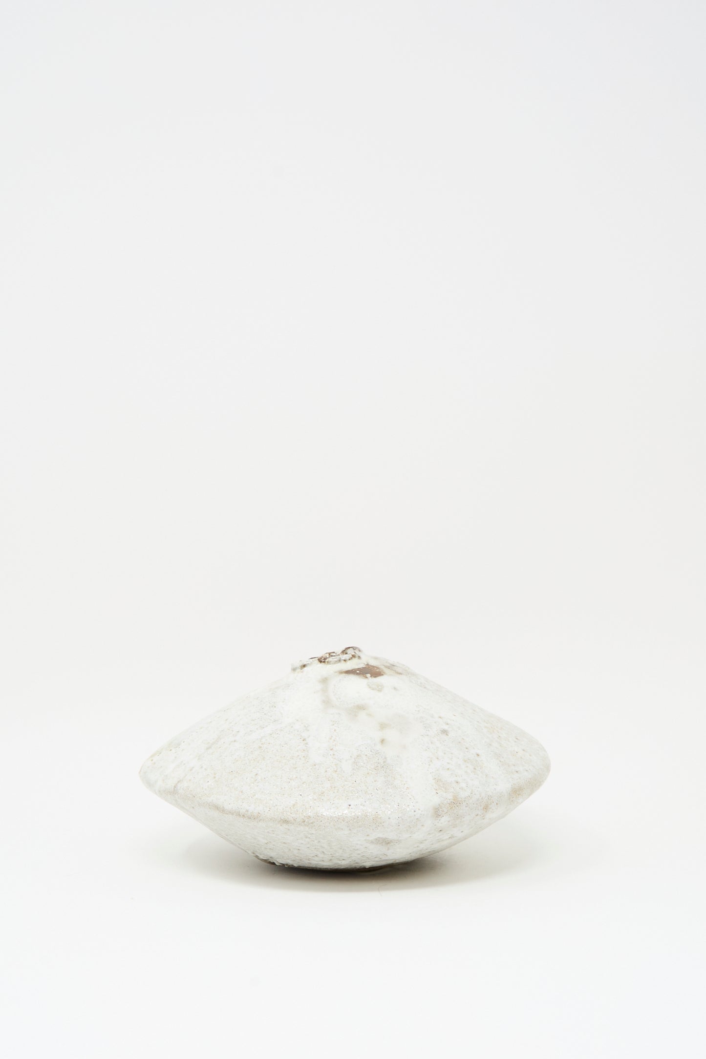 The MONDAYS Ikebana Vase in White over Dark Brown is a round, flat hand-built vase with a central opening, finished in smooth white glaze and displayed against a plain white background.