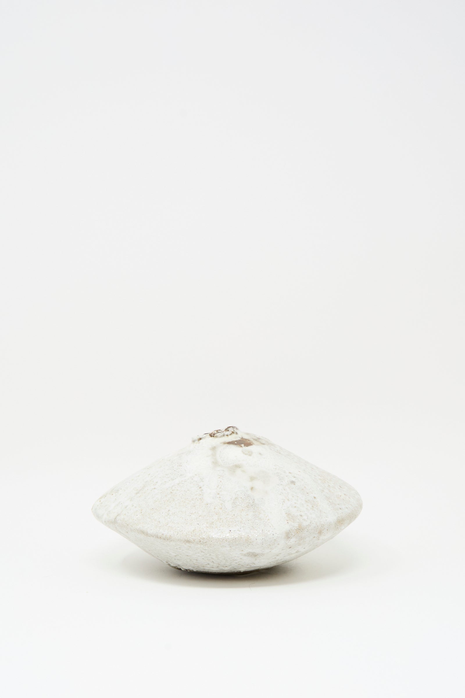 The MONDAYS Ikebana Vase in White over Dark Brown is a round, flat hand-built vase with a central opening, finished in smooth white glaze and displayed against a plain white background.