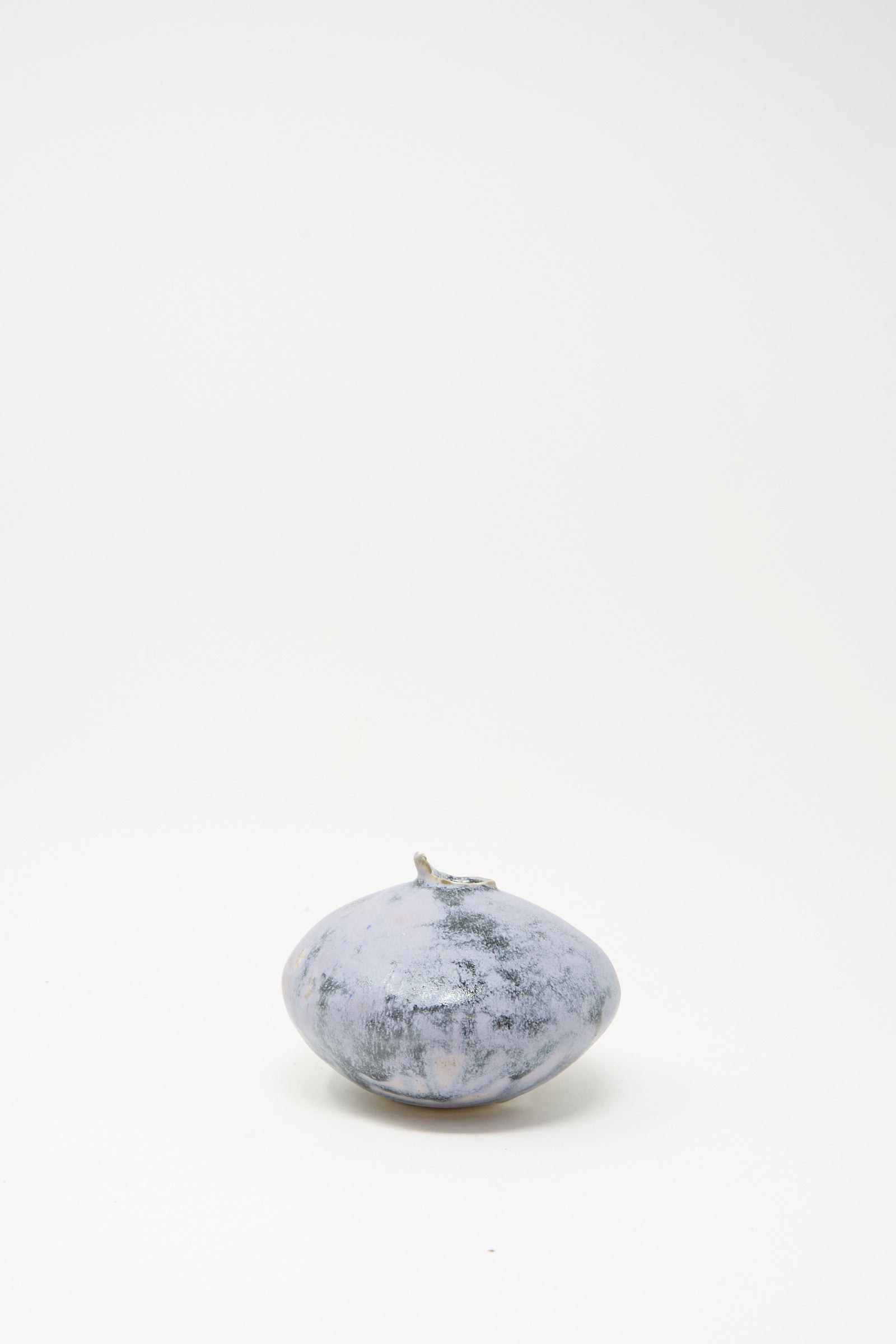The MONDAYS Mini Moon Vase in Blue is a round, grayish-blue handmade stoneware vase with a short stem, shown on a plain white background.