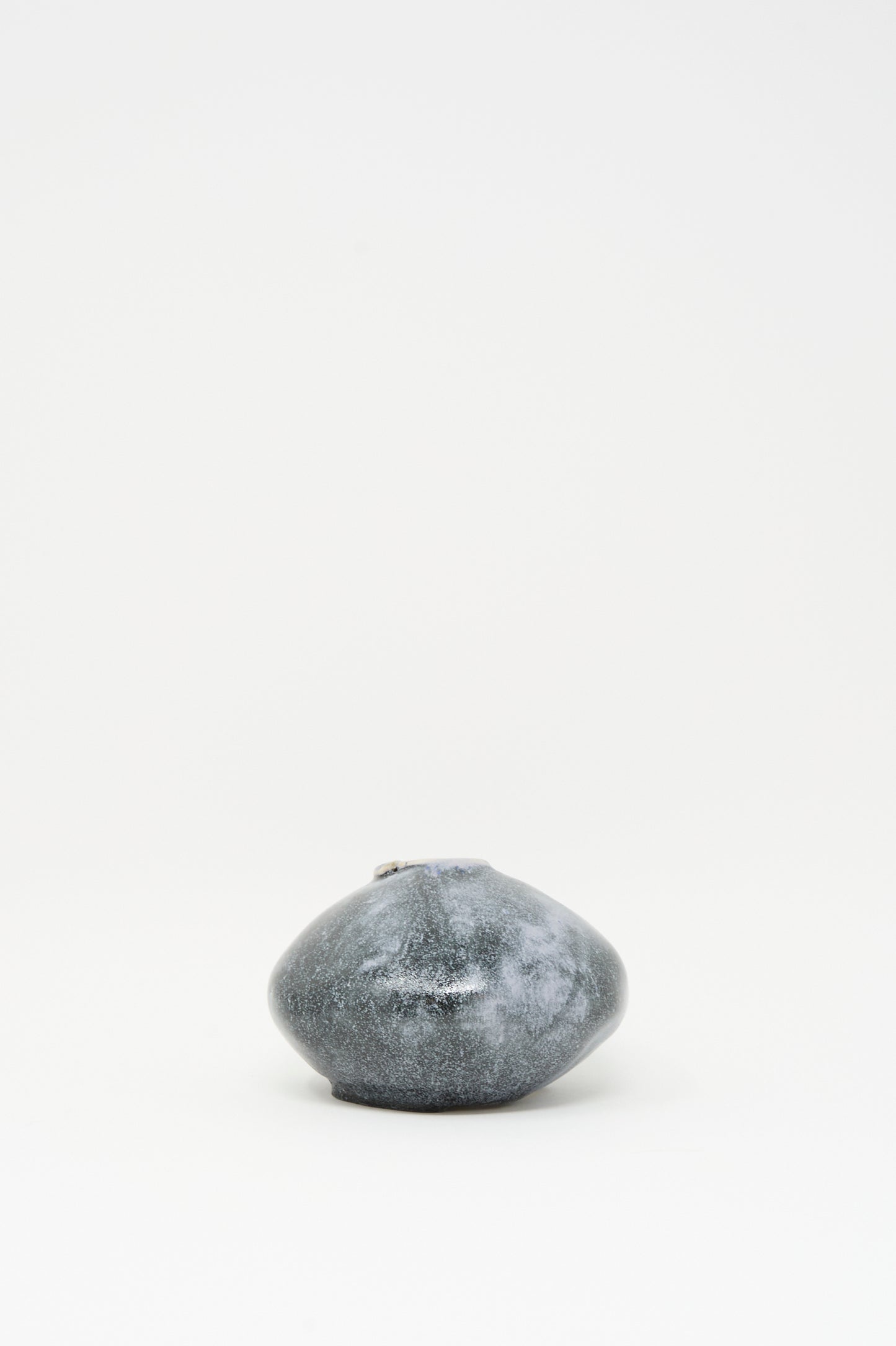 The MONDAYS Moon Vase in Storm is a small, round, dark gray ceramic vase with a narrow opening and subtle blue glaze accents, displayed centered on a plain white background.