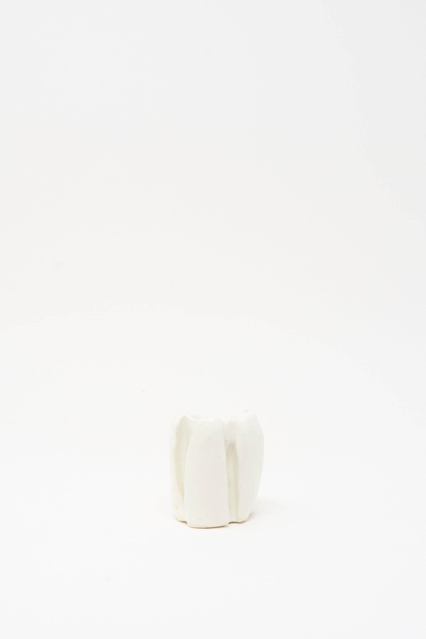 The Ribbed Candleholder in White by MONDAYS, a handmade porcelain piece from Brooklyn, is showcased alone against a plain white background.