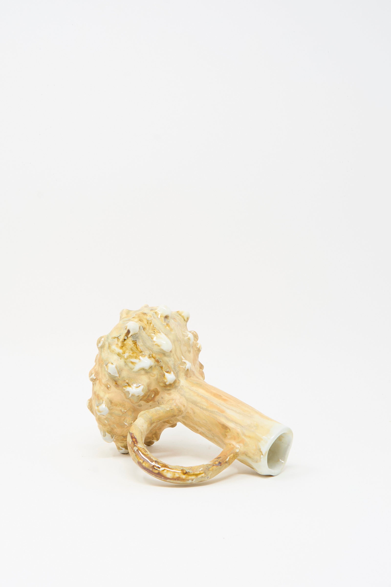 The MONDAYS Soda-Fired Bottle Vase No. 7, handmade from porcelain with a textured bulbous end, cylindrical handle, and glossy beige-gold finish, is displayed on a white background.