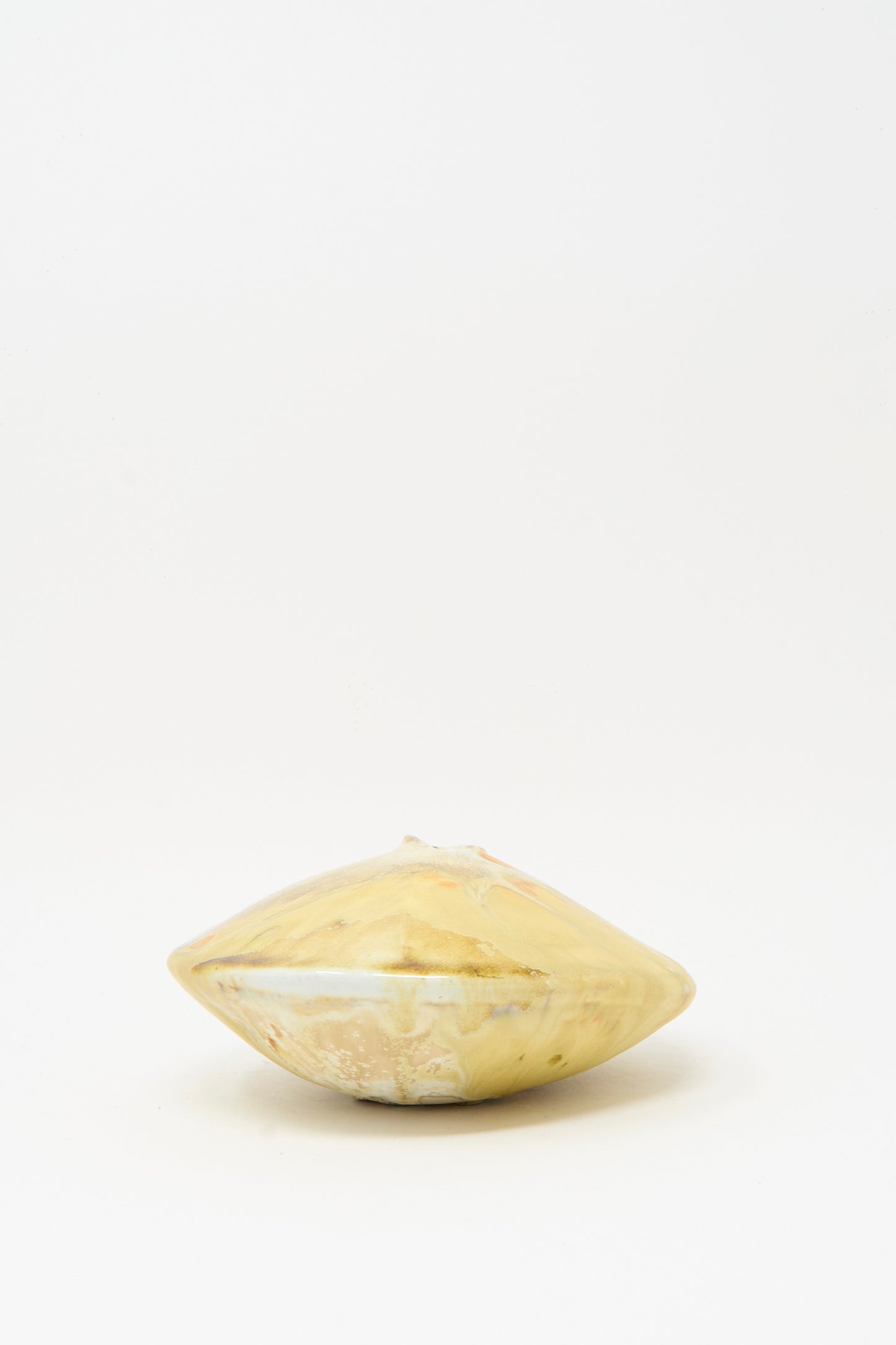 The MONDAYS Soda-Fired Ikebana Vase No. 1, featuring a round yellow-beige form and a smooth, glossy finish, sits on a plain white background.