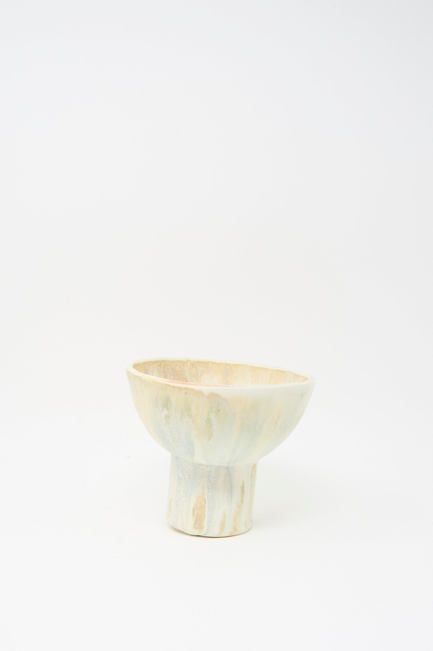 The MONDAYS Soda-Fired Pedestal Bowl features a handmade, light-toned design with a wide rim and cylindrical base, crafted from soda-fired porcelain and photographed on a plain white background.