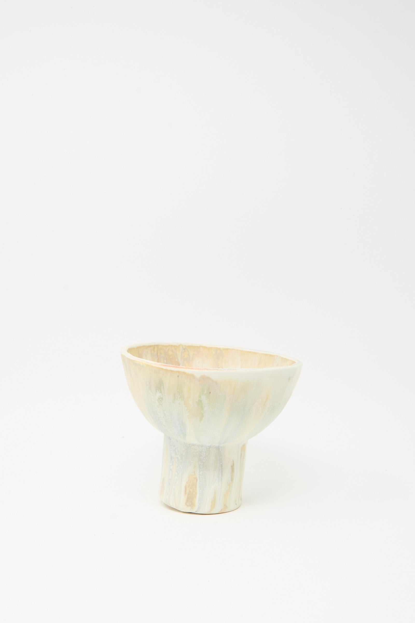 The MONDAYS Soda-Fired Pedestal Bowl features a handmade, light-toned design with a wide rim and cylindrical base, crafted from soda-fired porcelain and photographed on a plain white background.
