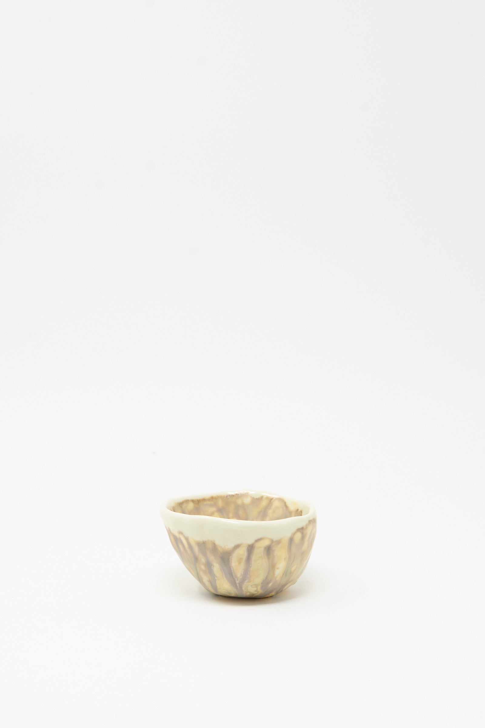 The Soda-Fired Pinched Bowl II by MONDAYS is a small handmade bowl with a cream and brown glaze, crafted in Upstate NY pottery style, shown on a plain white background.