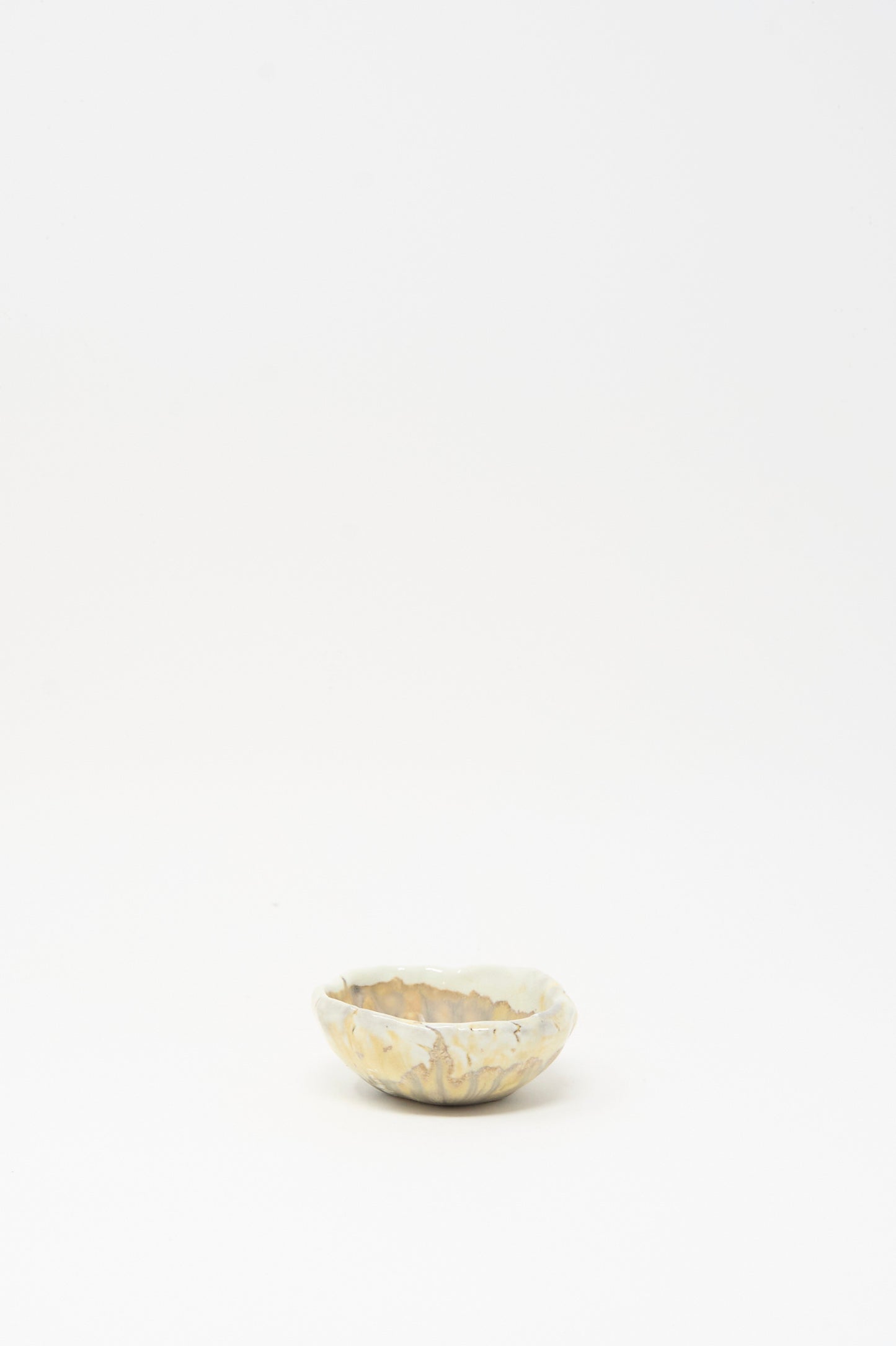 The Soda-Fired Pinched Bowl III by MONDAYS is a small, shallow handmade bowl with a wavy rim and light marbled glaze, displayed on a plain white background—capturing the essence of Upstate NY pottery.