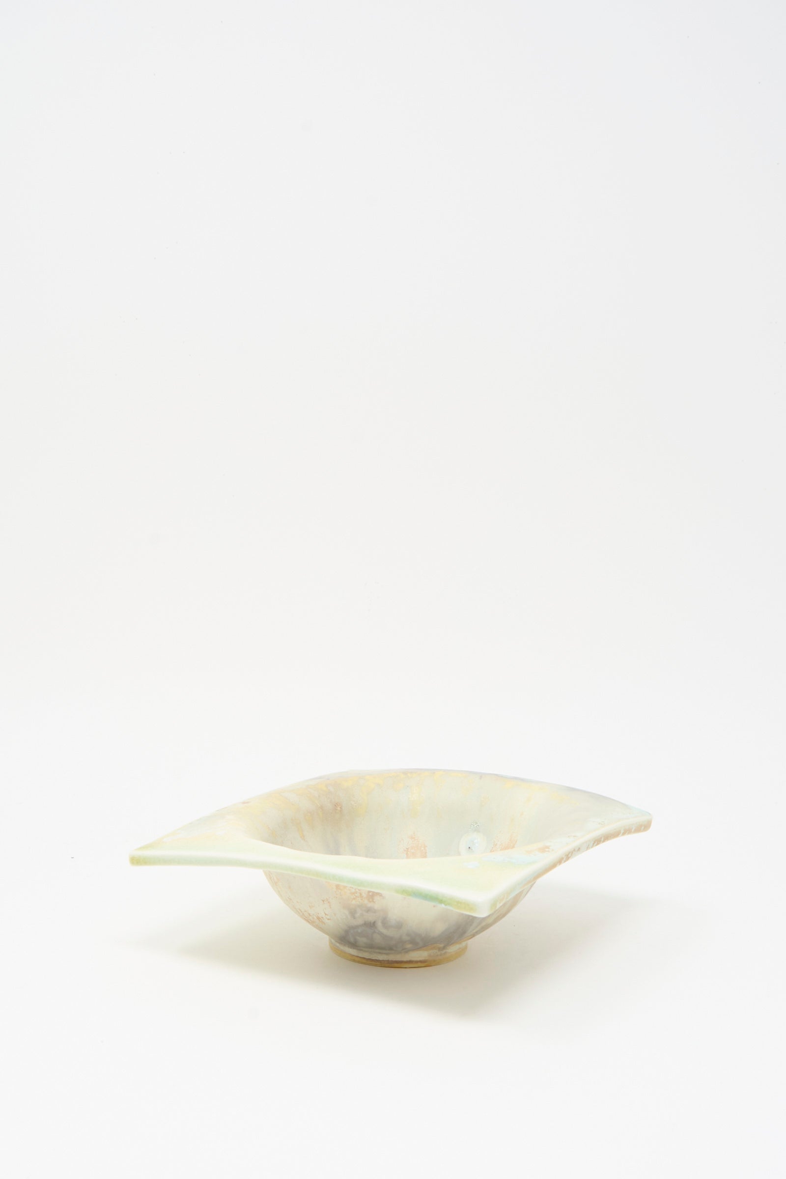The MONDAYS Soda-Fired Porcelain Square Bambi Bowl features a shallow, handmade design with a wavy rim, light blue glaze, and subtle marbled pattern, shown against a plain white background.