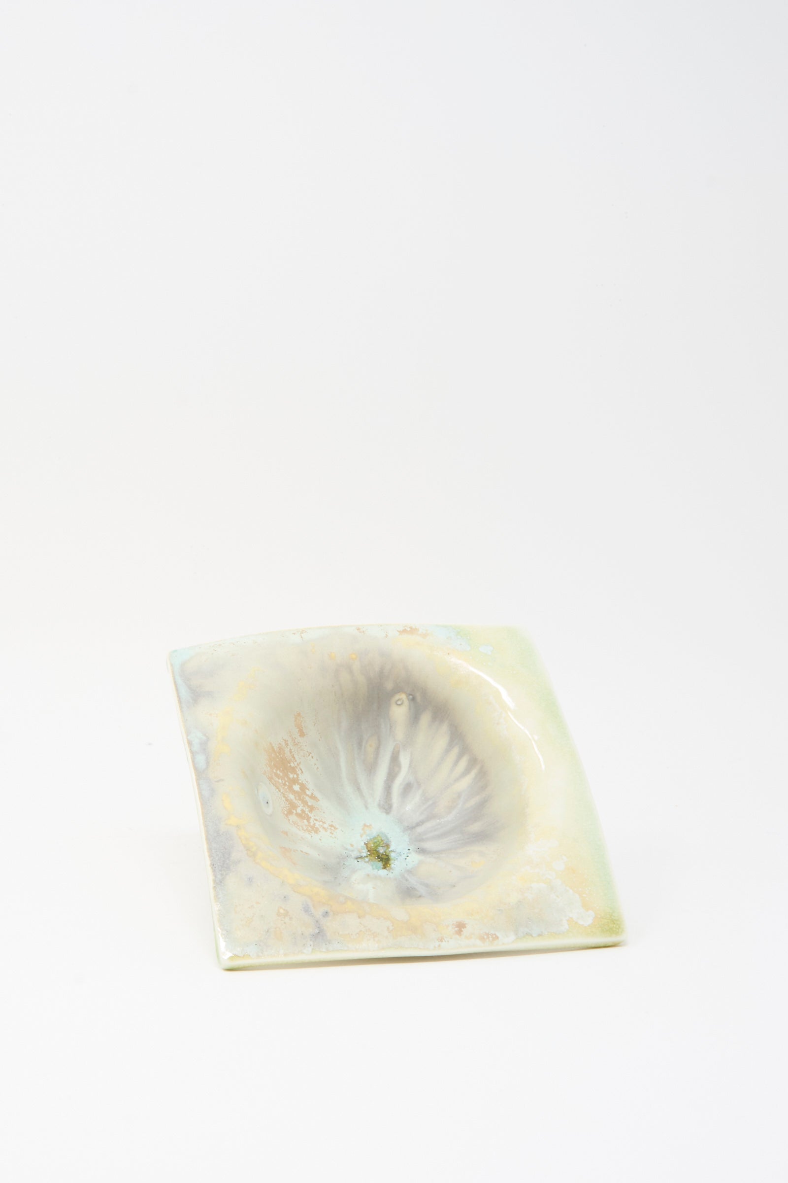 The MONDAYS Soda-Fired Porcelain Square Bambi Bowl is a small, square bowl with a marbled pale glaze and a shallow, uneven center depression.