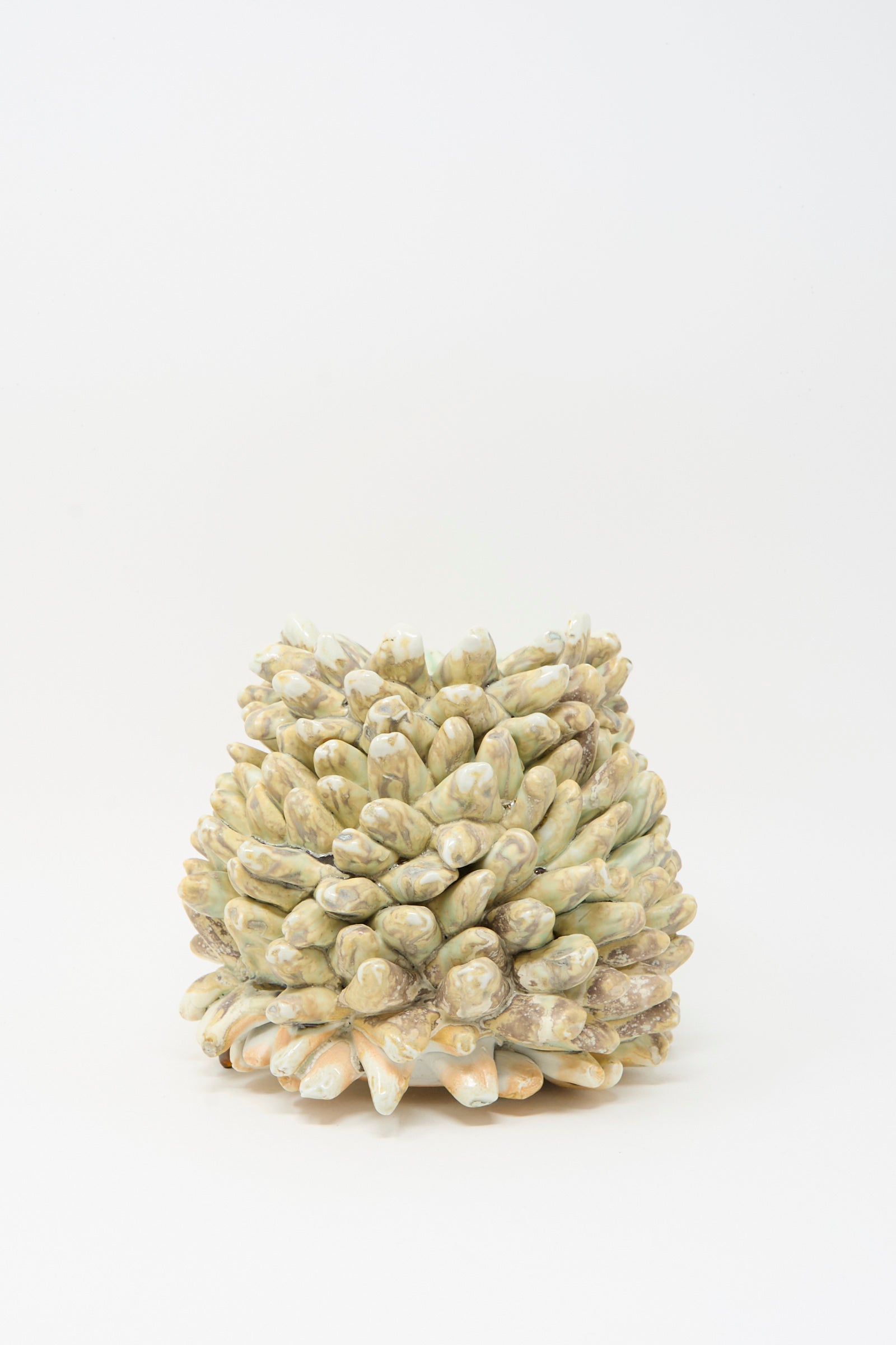 The MONDAYS Soda-Fired Rasmus Bump Vase features small, round, beige and greenish pine cone-like scales and is handmade from porcelain, shown here against a plain white background.