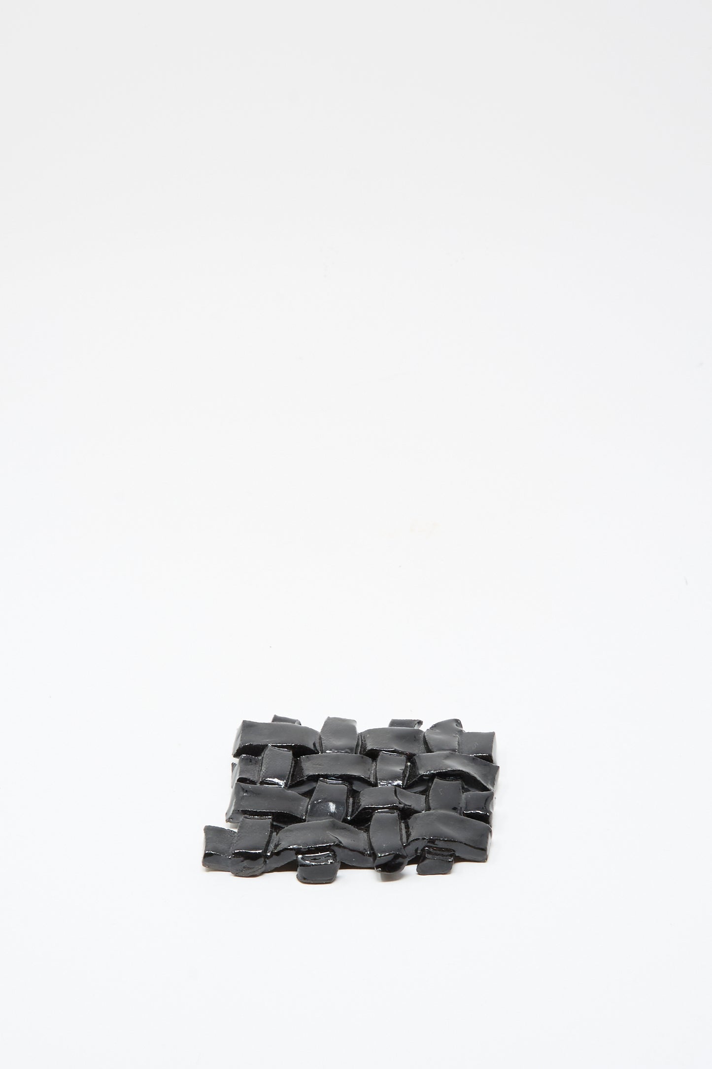 The MONDAYS Woven Dish in Black, a small rectangular ceramic piece with black glaze, is crafted with care and photographed on a plain white background.