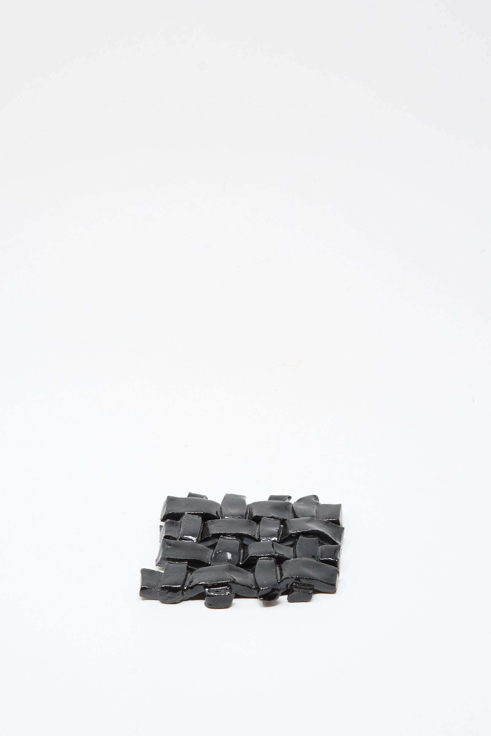The MONDAYS Woven Dish in Black, a small rectangular ceramic piece with black glaze, is crafted with care and photographed on a plain white background.