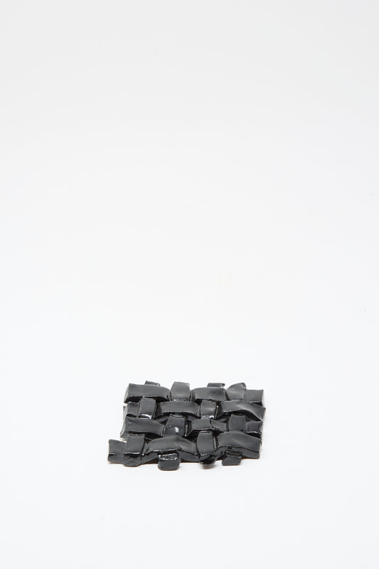 The MONDAYS Woven Dish in Black, a small rectangular ceramic piece with black glaze, is crafted with care and photographed on a plain white background.