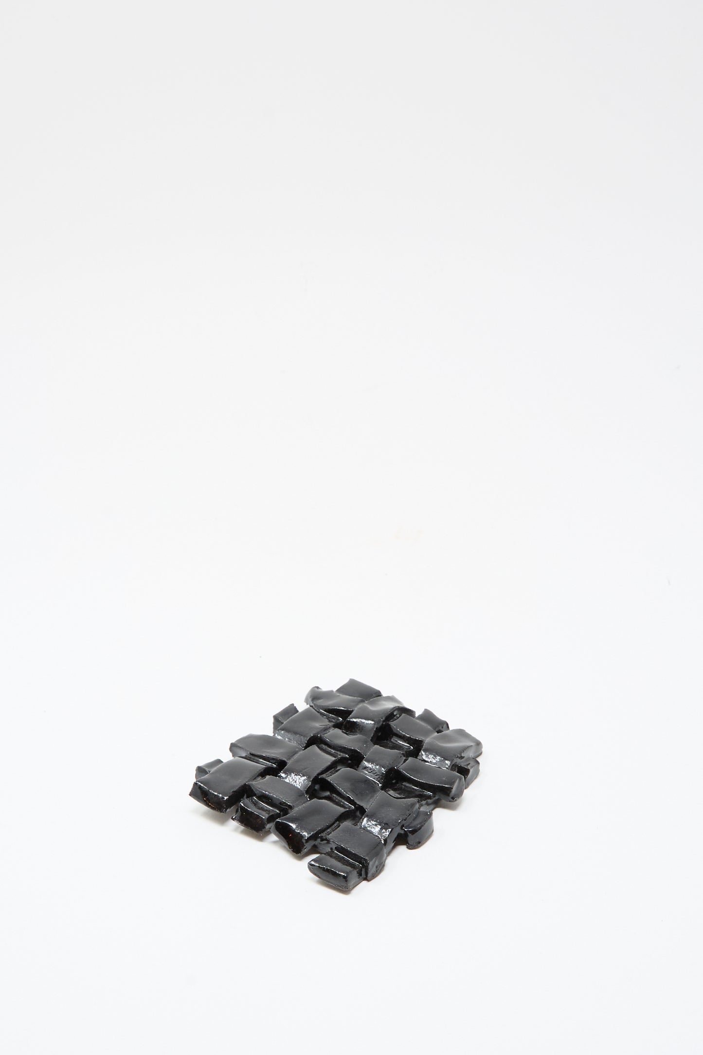 The MONDAYS Woven Dish in Black, a small rectangular ceramic piece with a glossy finish, is shown on a plain white background.