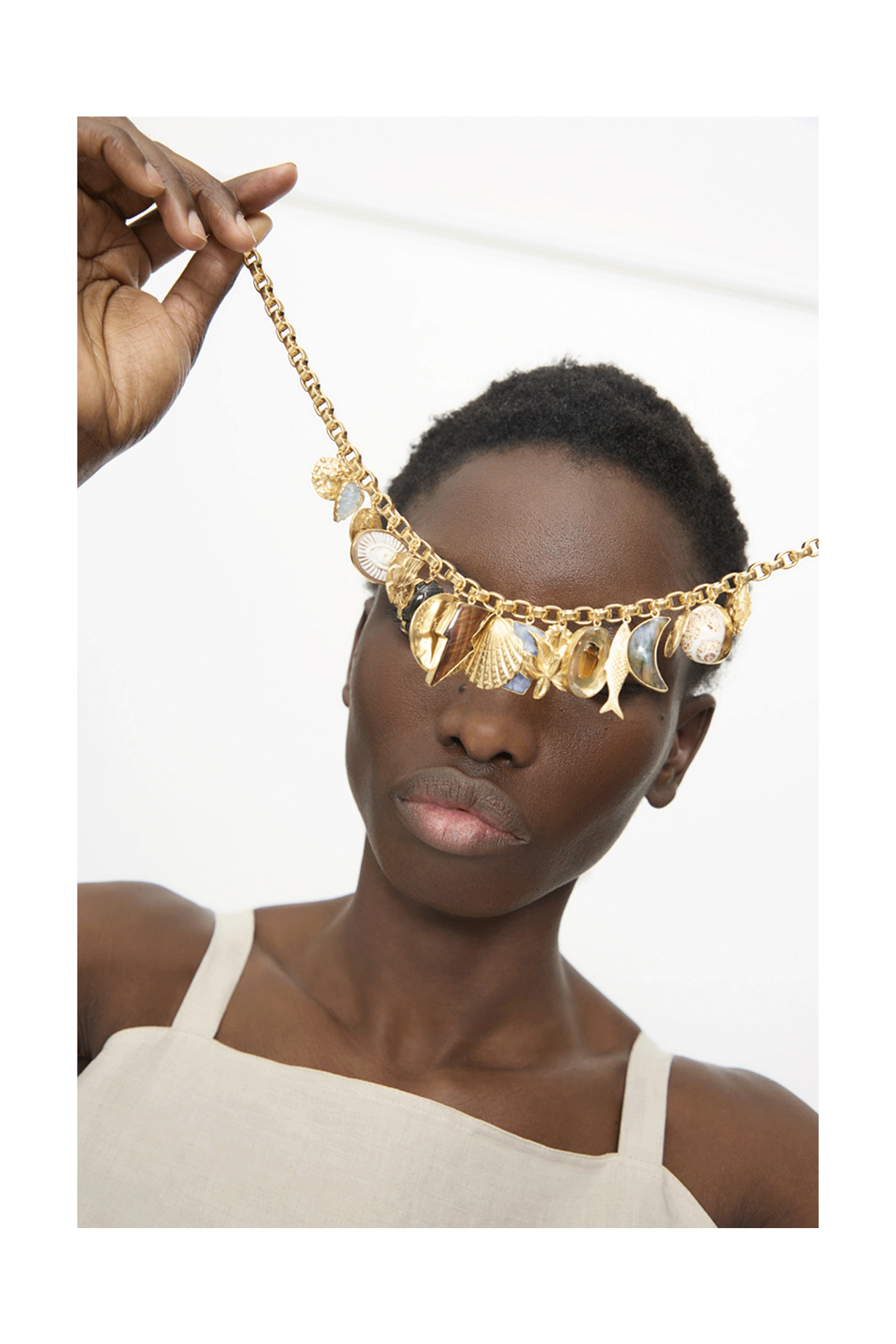 A gif of different products from the Mother's Day Gift Guide featuring a woman in the center holding the Grainne Morton Chunky Charm Necklace over her eyes.
