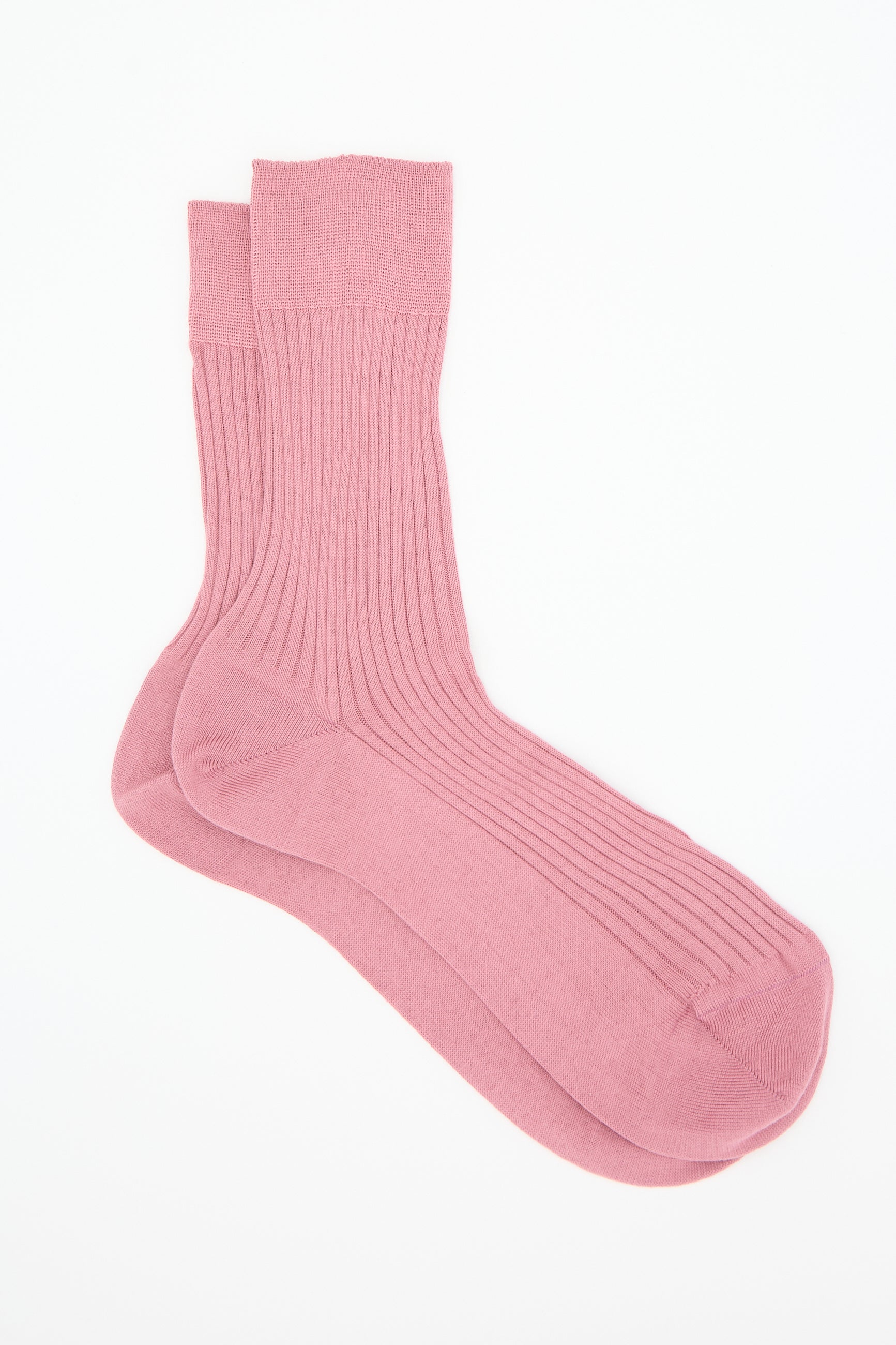 A pair of the Bio Sock in Cameo by Maria La Rosa, crafted from ribbed cotton in a light pink hue and designed to reach mid-calf, is laid flat against a white background.