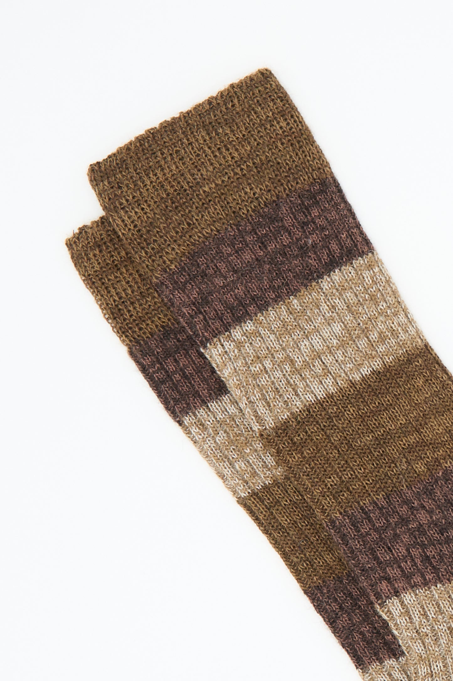 A pair of "Sock in Brown" by Maria La Rosa, featuring brown and beige stripes in a ribbed wool blend, set against a white background.