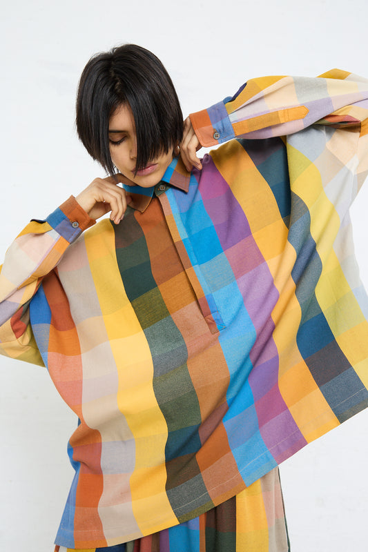 Woman adjusting an oversized, colorful Marrakshi Life Cropped Tunic in Multi Check.