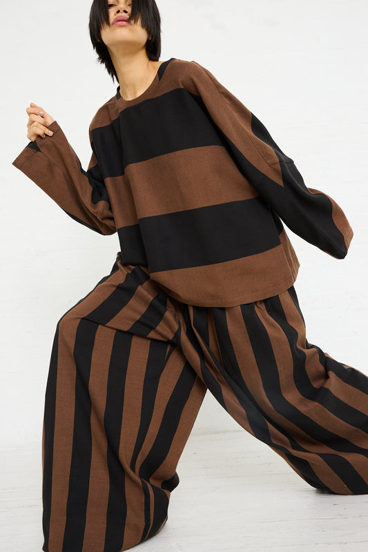 Woman in a Marrakshi Life Drawstring Pleated Pant in Black and Brown Stripe outfit with wide leg pants, posing against a white background.